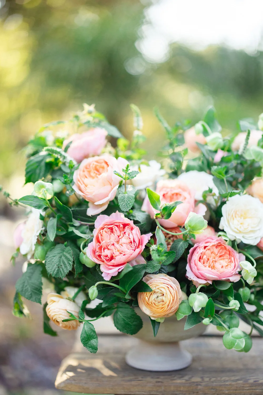 A loose, abundant arrangement of garden roses and ranunculus