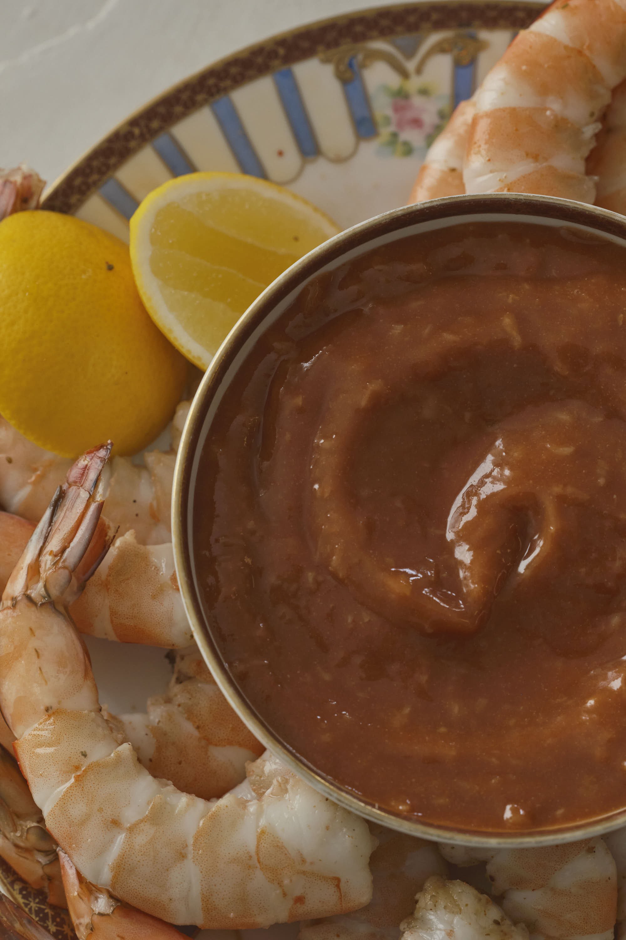 Shrimp with lemon wedge served with cocktail sauce.