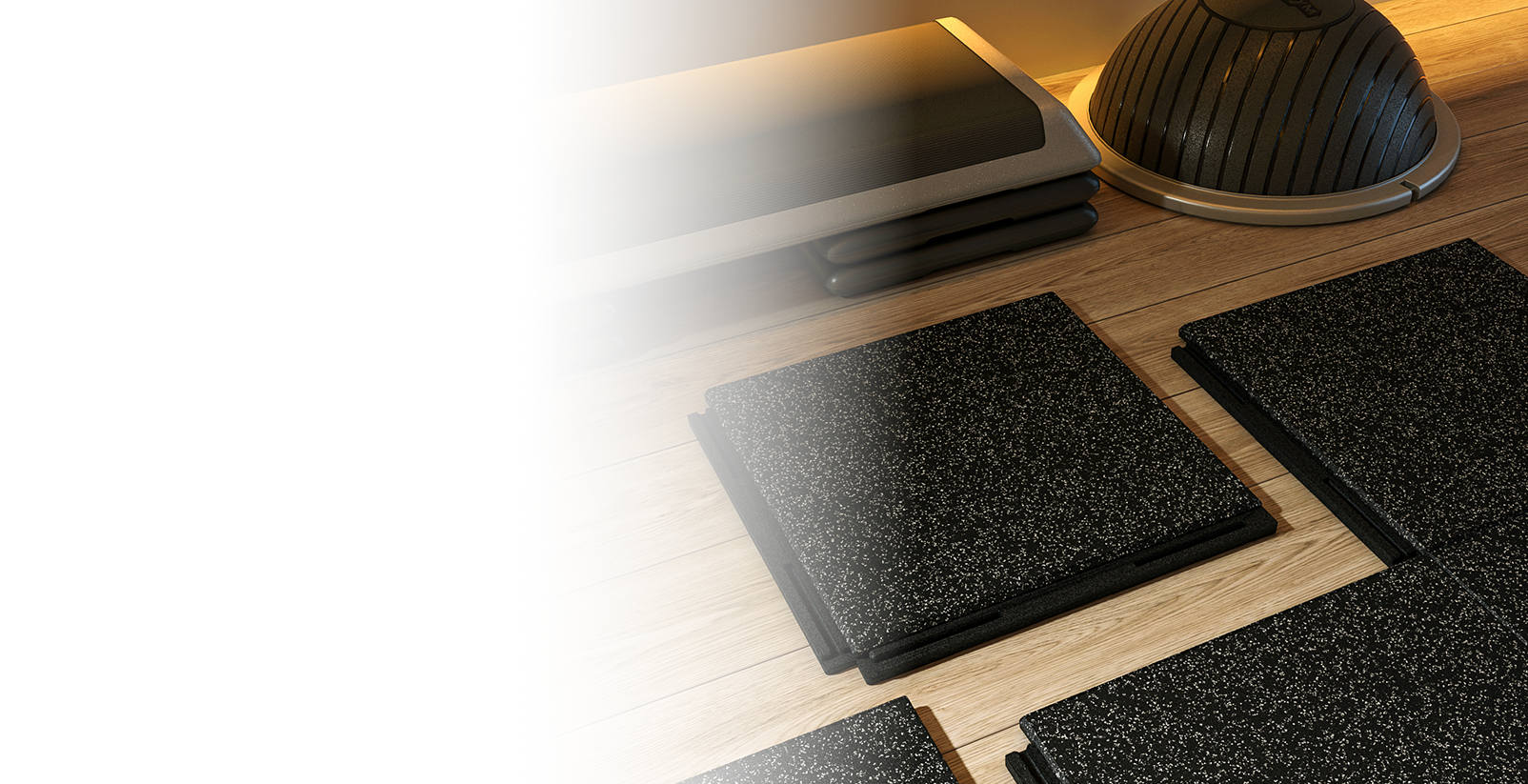 Material de yoga en una superficie de madera, incluyendo bloques, una esterilla, y una bola de equilibrio.