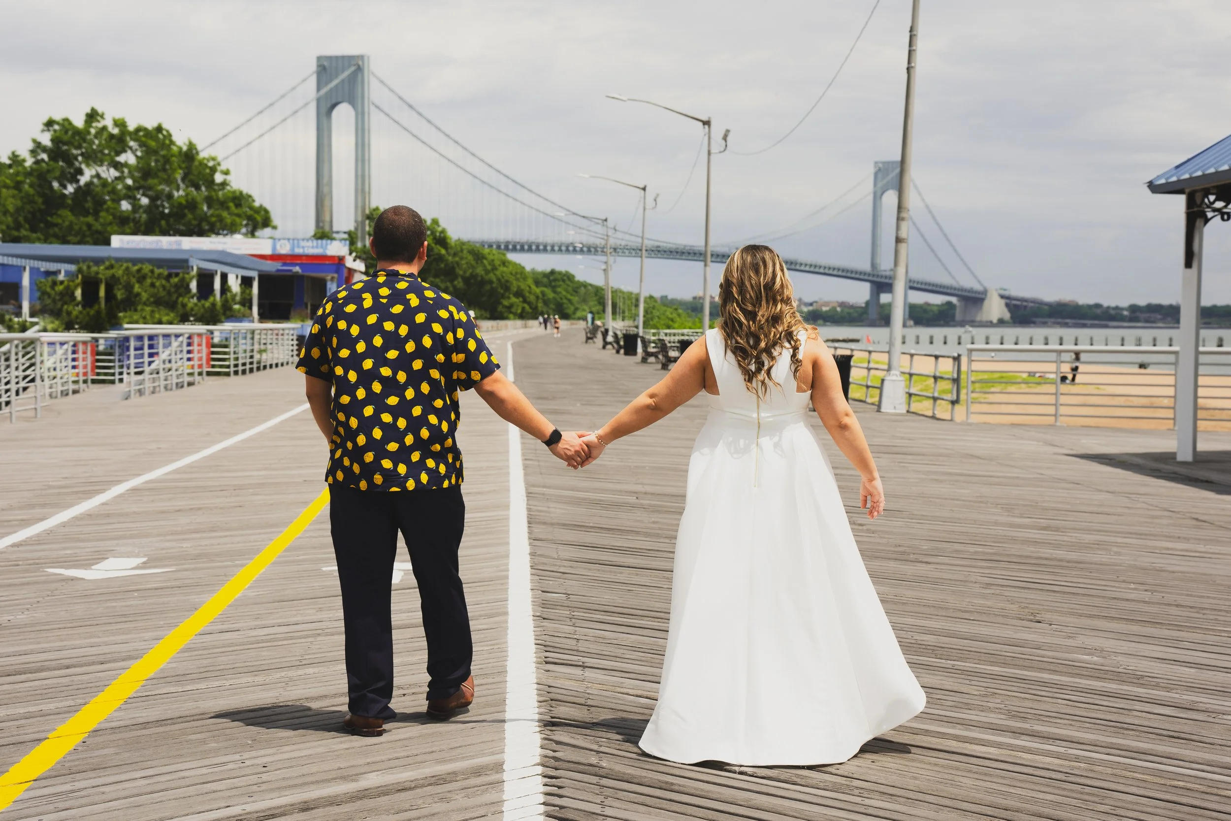 Couple holding hands on boardwalk near bridge
