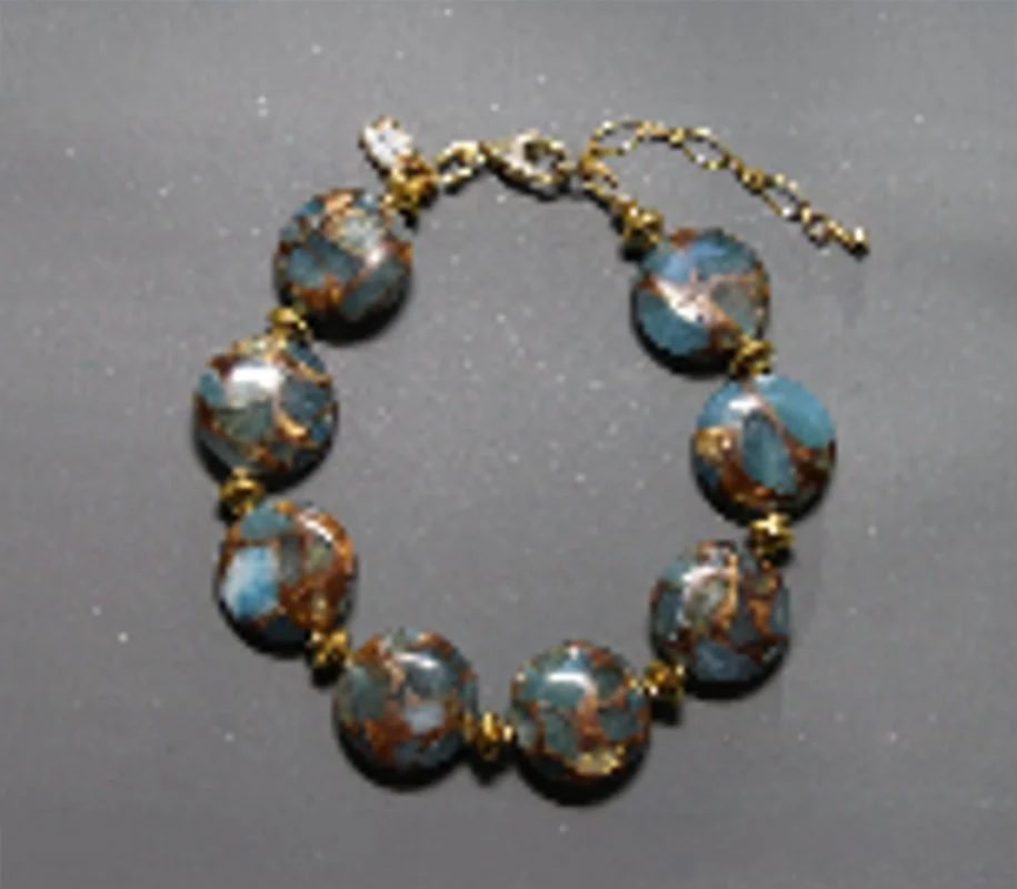 Blue and brown patterned beaded bracelet with gold accents and chain clasp.