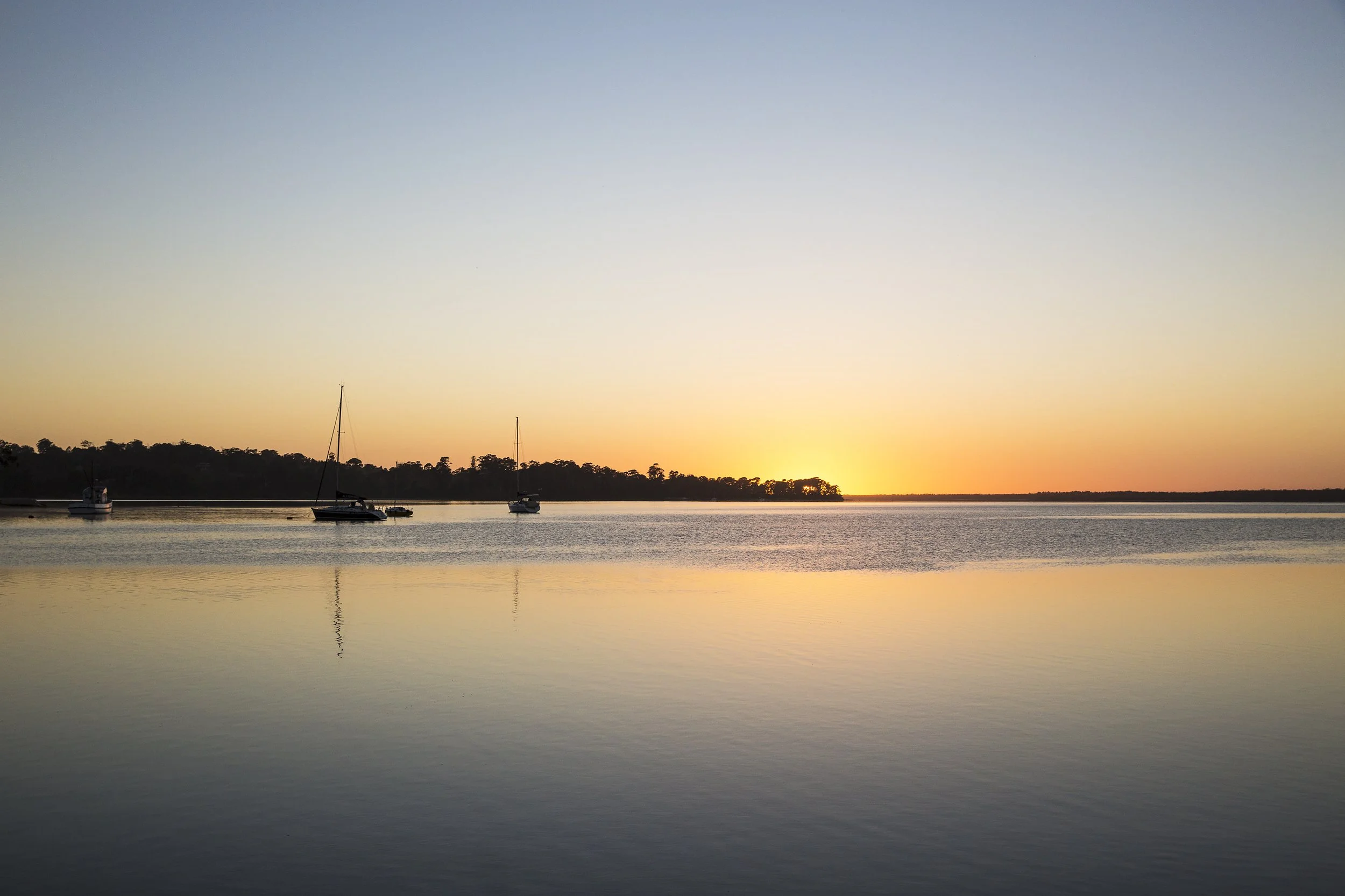 Wide shot of boats and sunset
