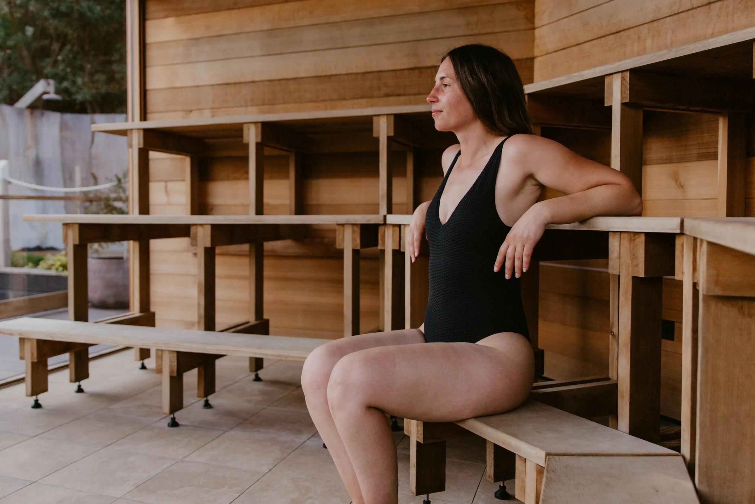 A woman relaxing in a wooden sauna