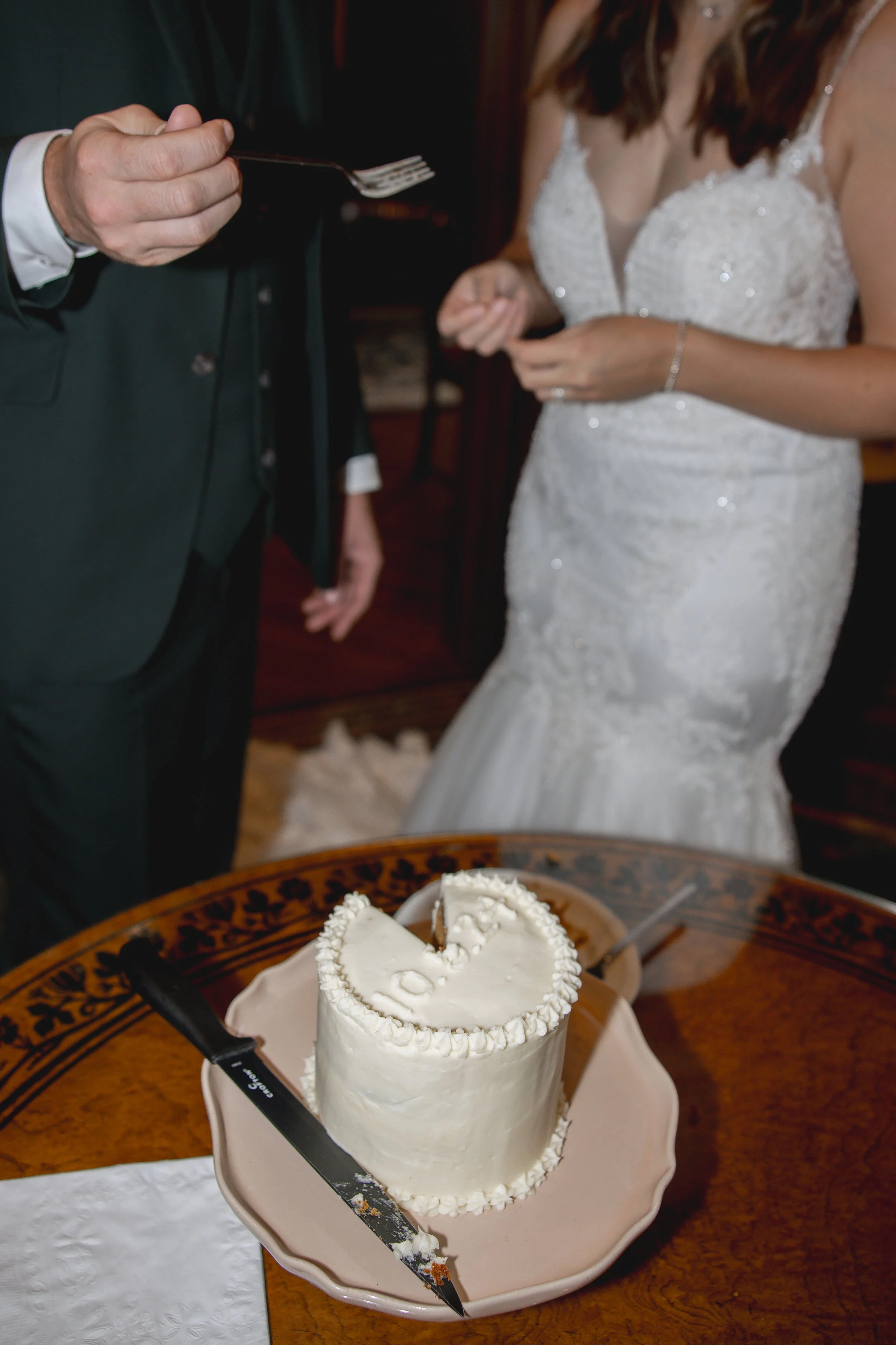 Groom feeding bride wedding cake
