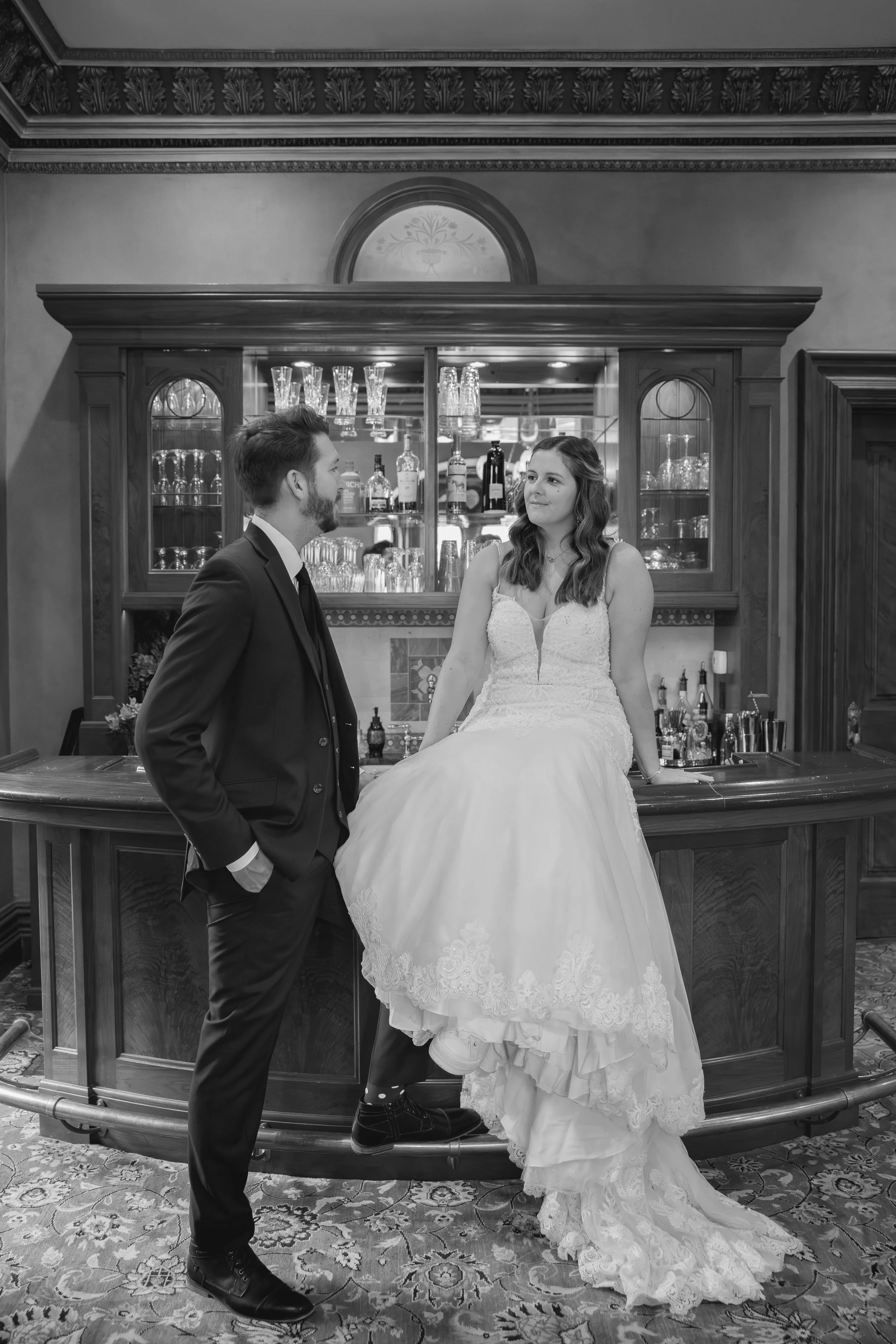 Bride and groom posing in front of antique bar