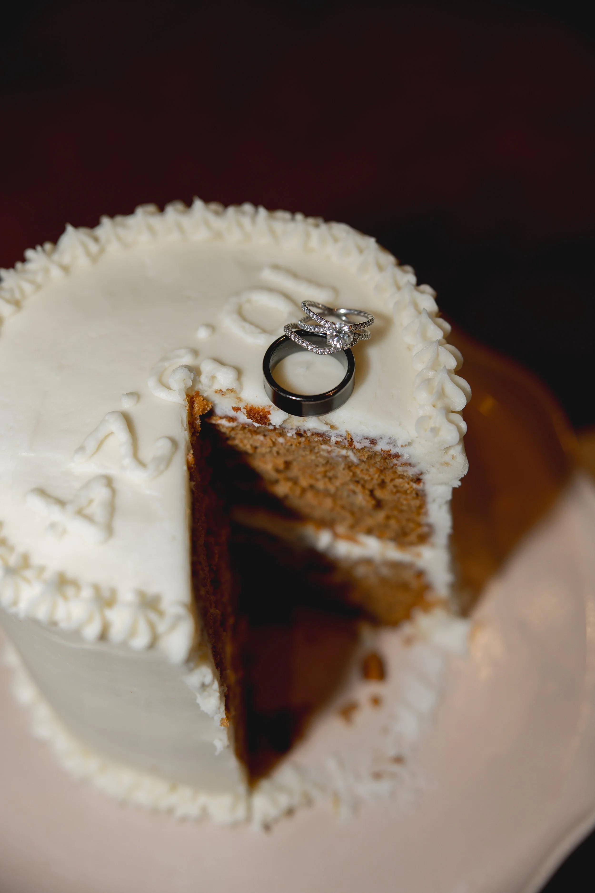 Wedding rings sitting on wedding cake