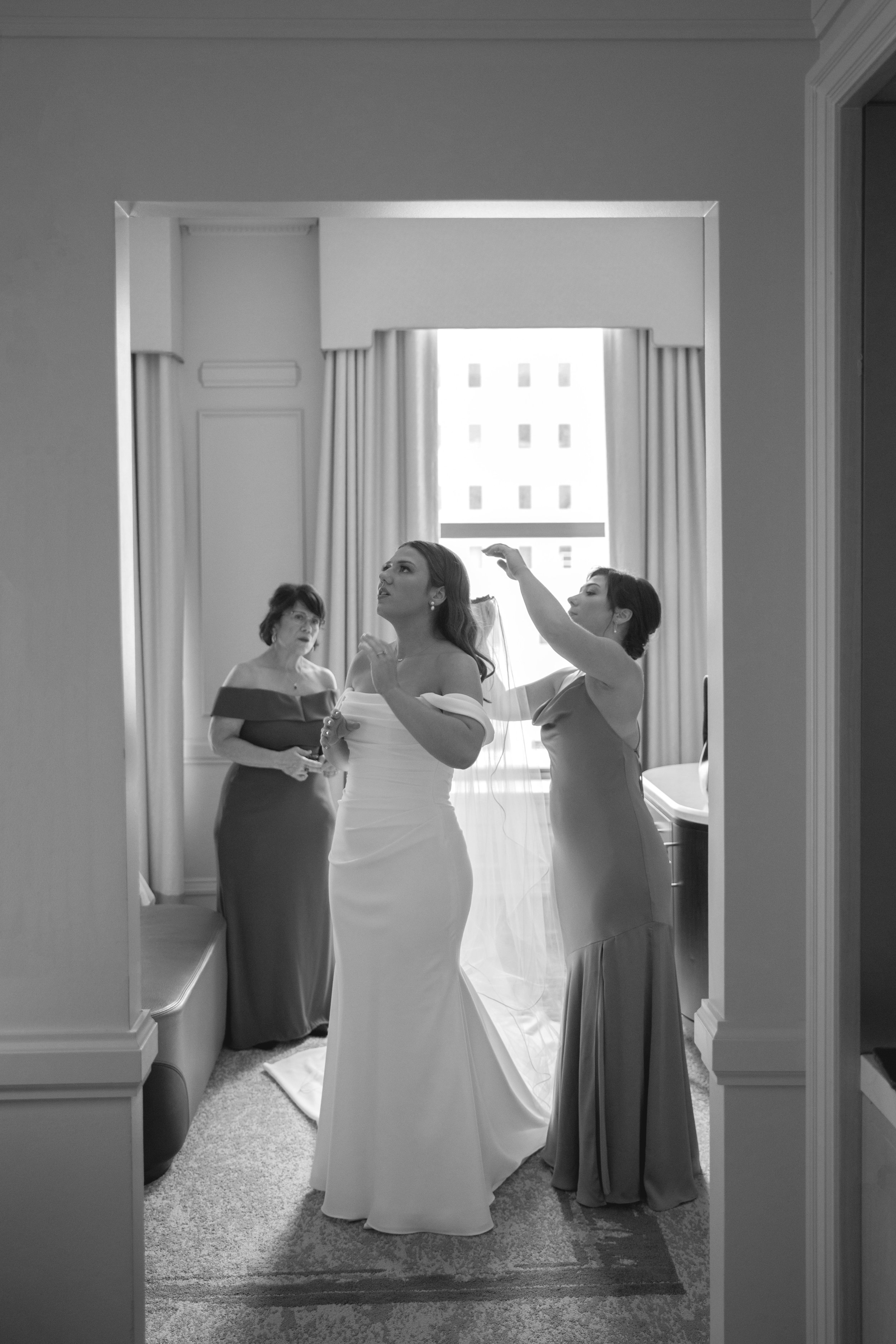 Mother helping bride with her veil
