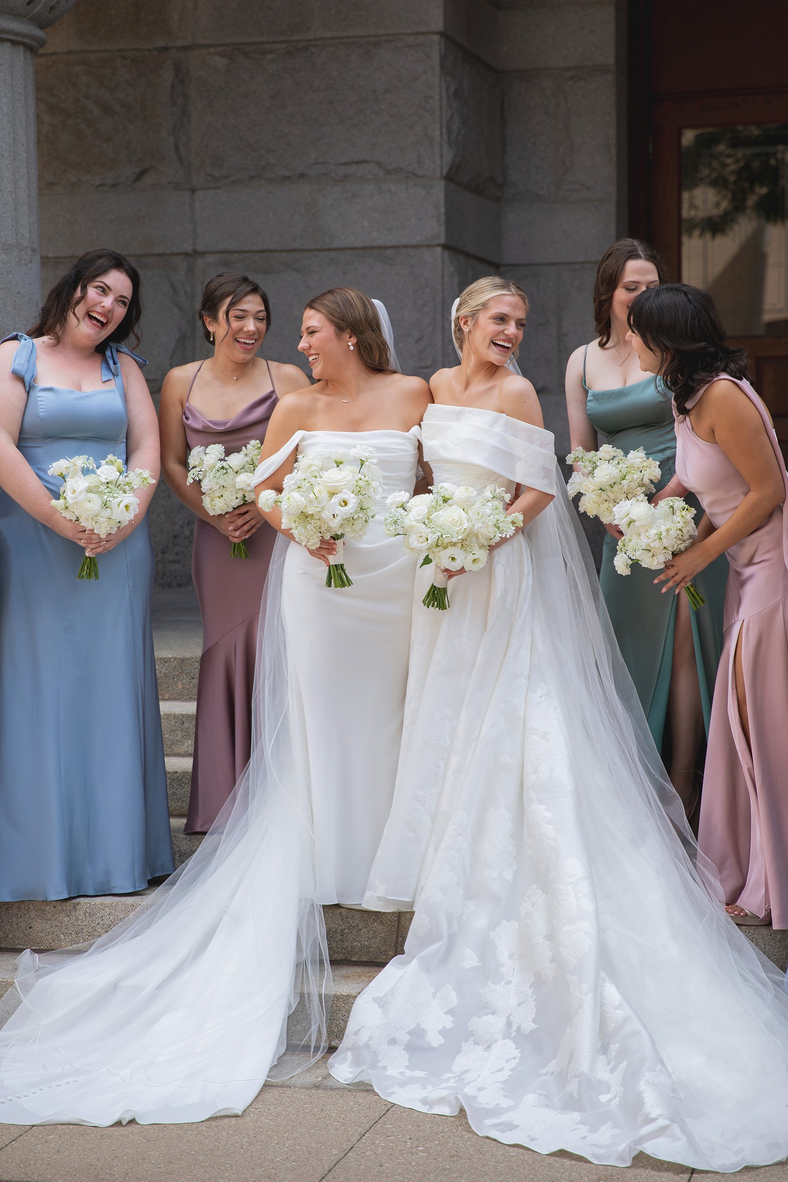 Brides laughing with their bridesmaids