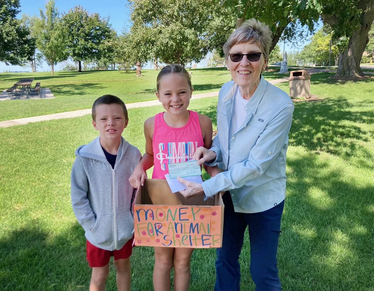 Member Sue, with Quinn Randall and her brother with the money they collected and donated to Caring Paws!