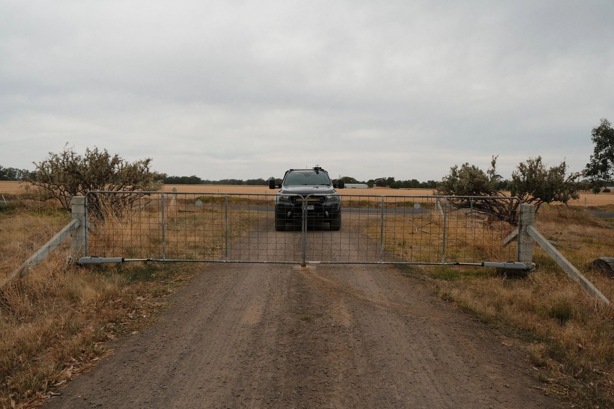 Automated gate — FAAC 415L double swing gate kit installed on to existing farm gates with concrete posts. 120w solar system, long range ATA remote controls, custom concrete in centre stop and wireless keypad