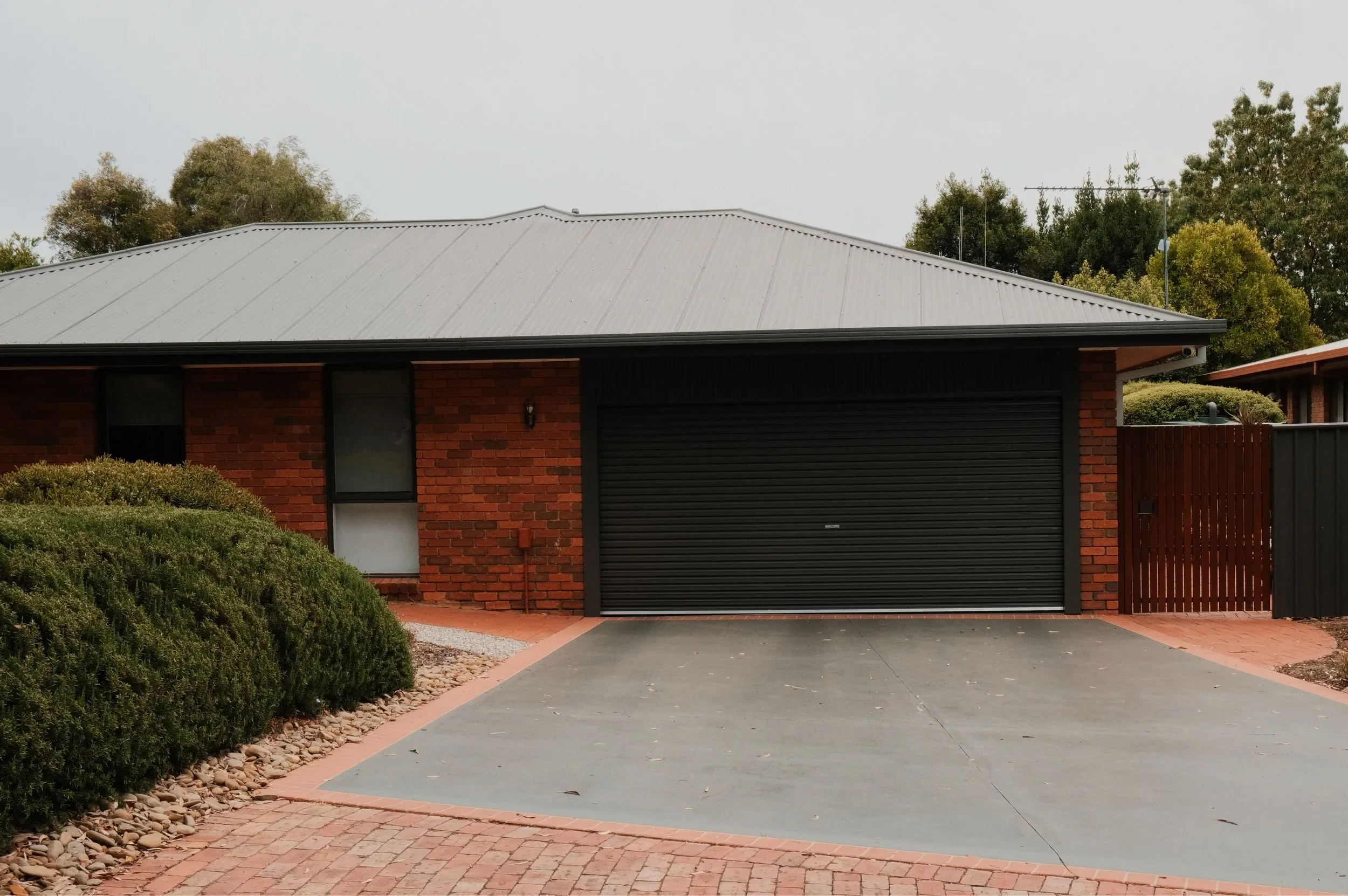 Brick+home+with+black+garage+door+roller.webp