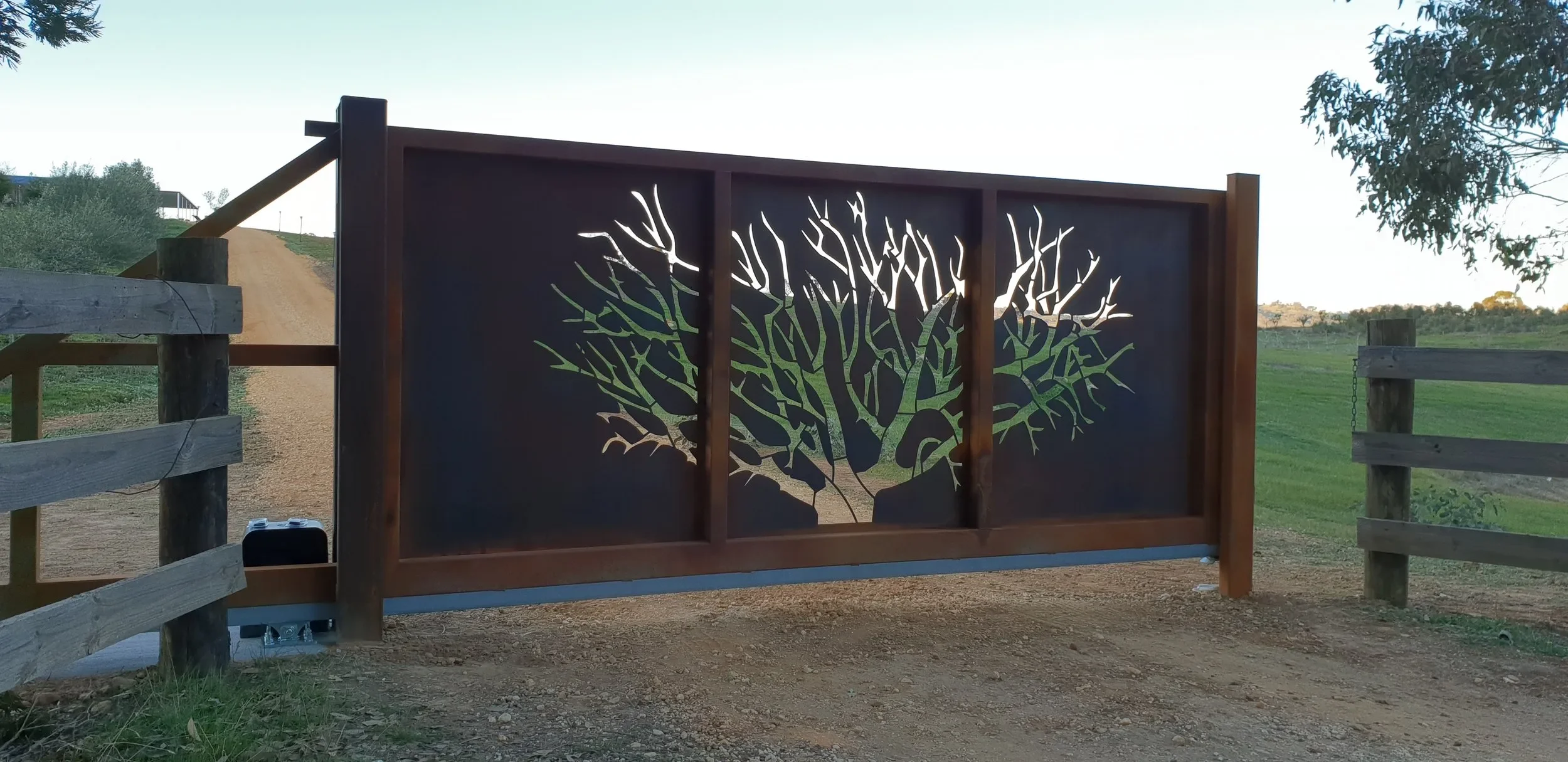 Tree laser cut into metal gate on farm