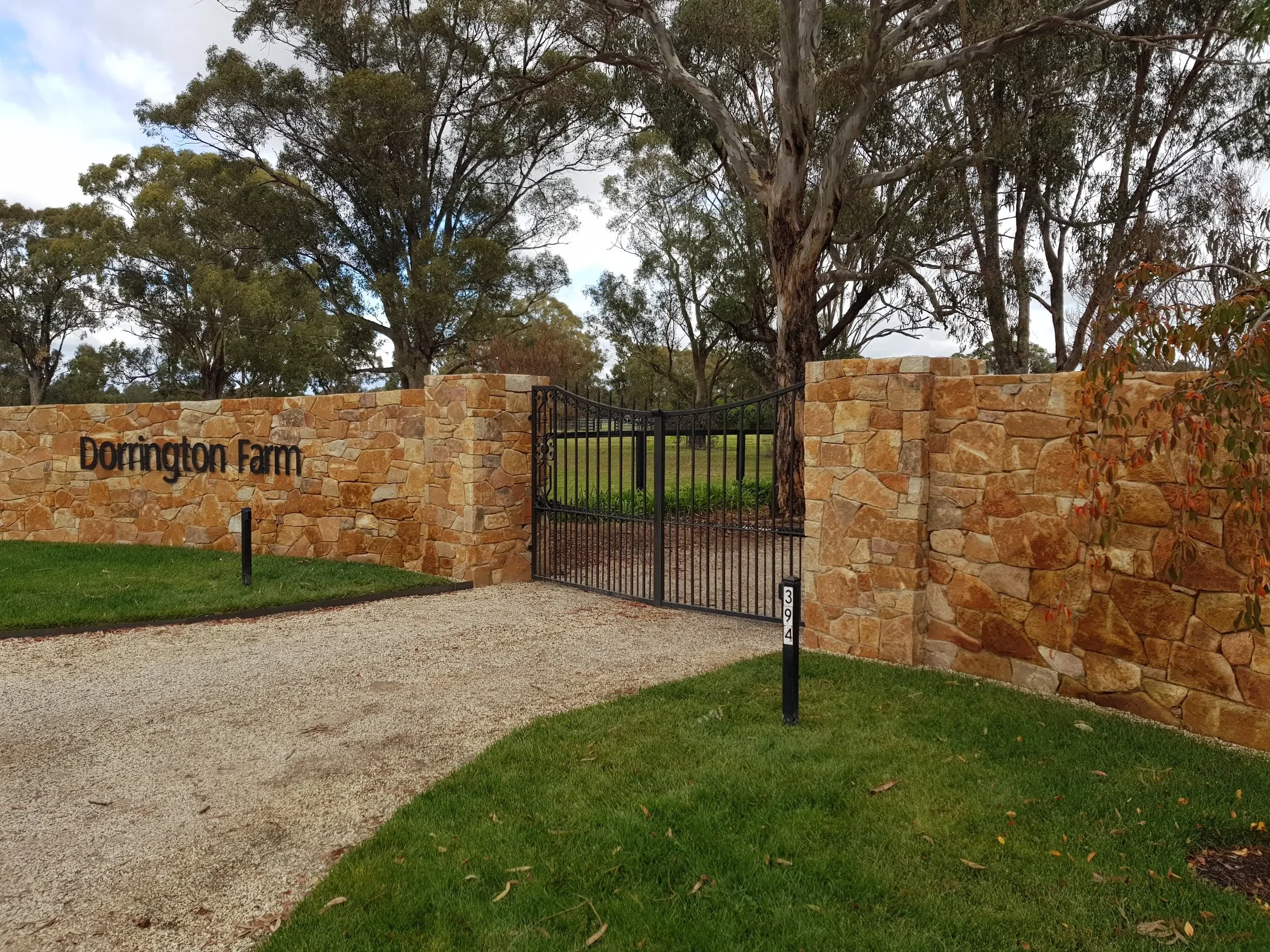 Iron+gate+on+brick+fence.webp