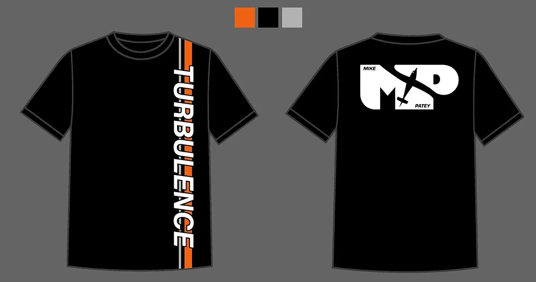 Black T-shirt with orange, black, and gray design on the front spelling 'TURBULENCE' vertically, and a white graphic on the back featuring the words 'MIKE PATEY' inside a stylized shape with a small airplane icon.