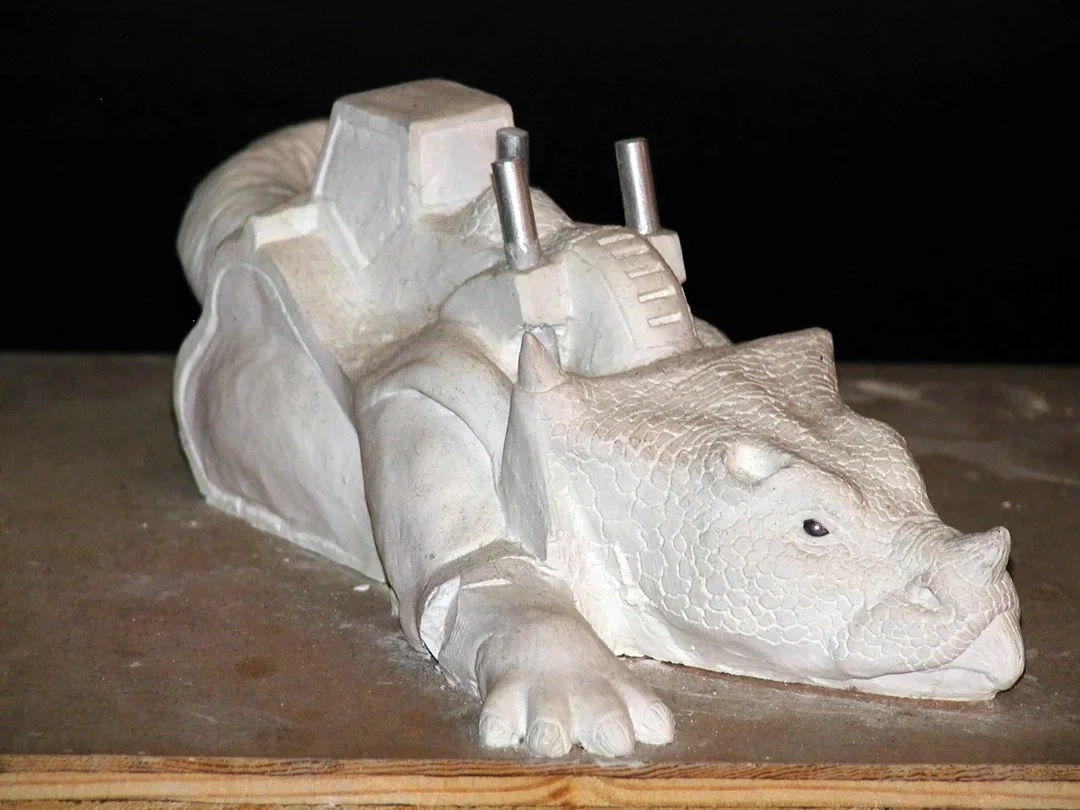 Clay model of a hybrid creature with the body of a tank and the head of a rhino.