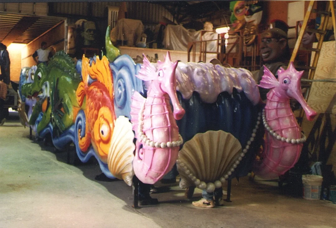 Colorful seahorse and ocean-themed parade float decorations in a workshop.