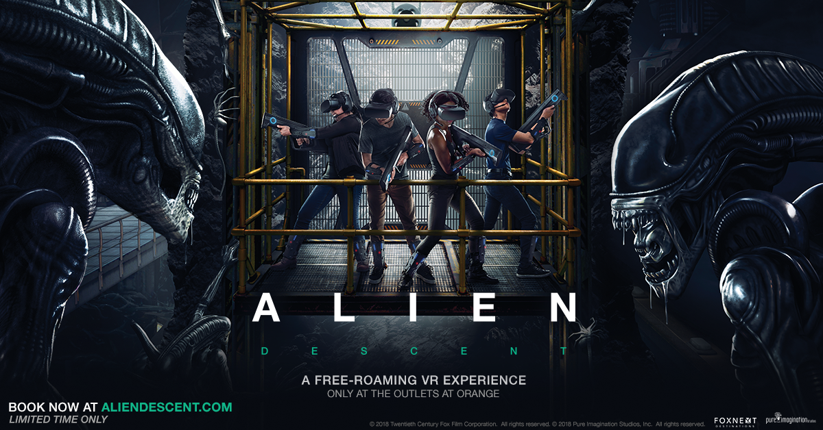 Four people wearing virtual reality headsets and holding guns, standing on a platform surrounded by Alien creatures in a sci-fi setting.