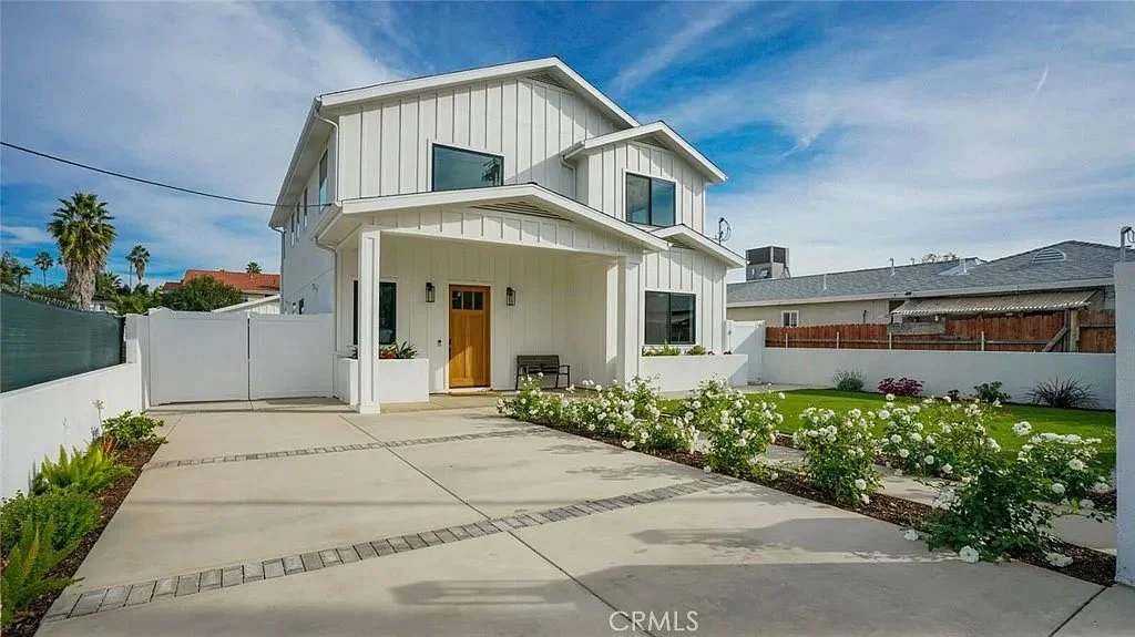 Modern two-story house with white siding, front lawn, and paved driveway