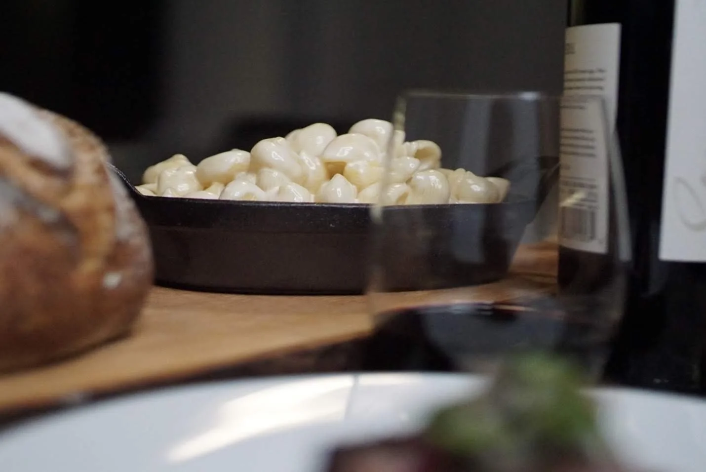 A bowl of white cheese curds or mozzarella balls on a black plate in a kitchen setting.