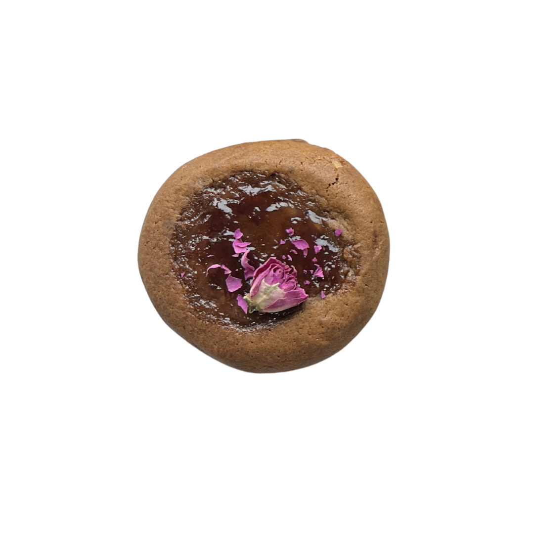 Gingerbread cookie topped with rose jam and dried petals for festive floral finish.
