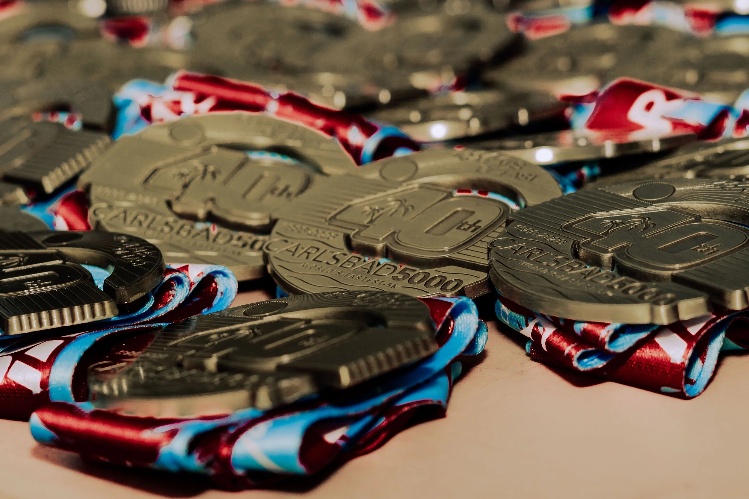 Close-up of shiny metallic poker chips with red, white, and blue patterned paper strips intertwined among them.