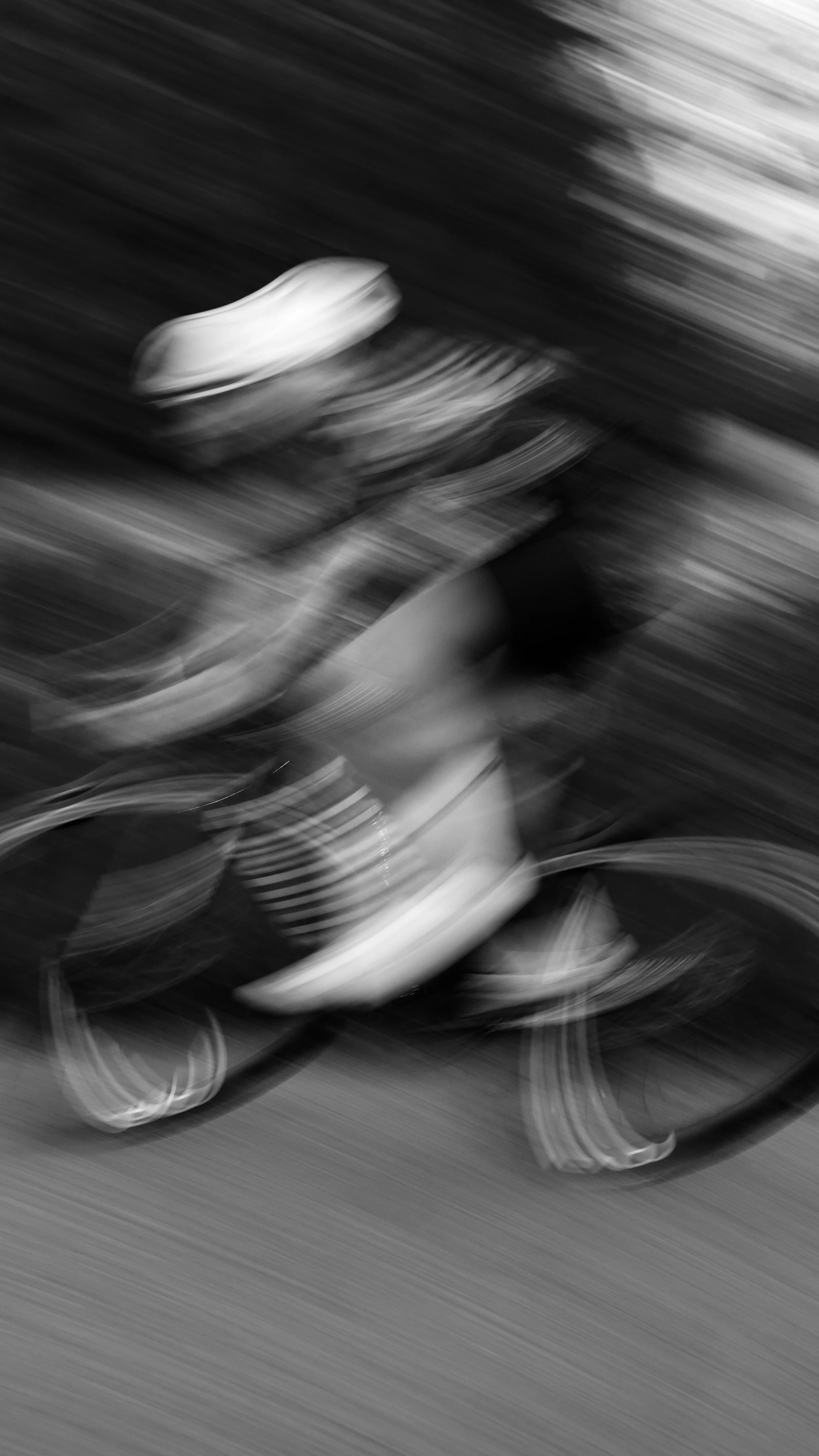 Blurred black and white photo of a sneaker on a shoebox, with swirling lines creating a motion effect.