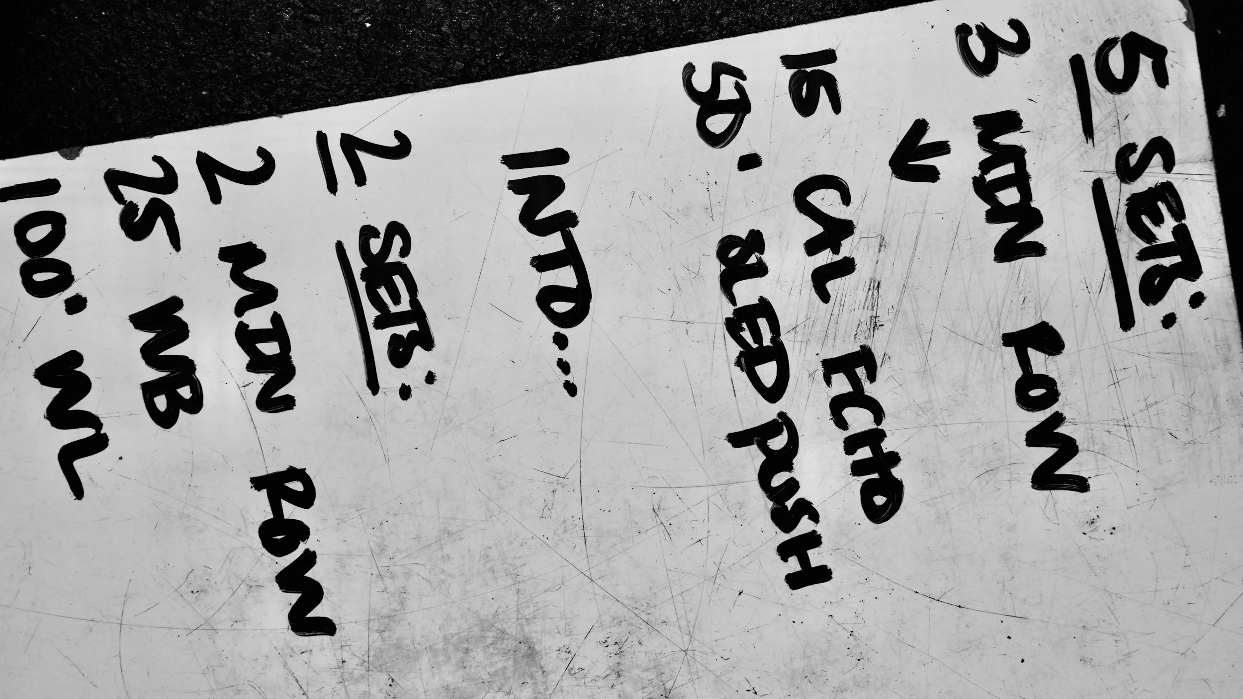 A whiteboard with handwritten notes and scoring, showing scores for multiple players or teams, with some words like 'LUNCH' and 'REPAIRS' visible.