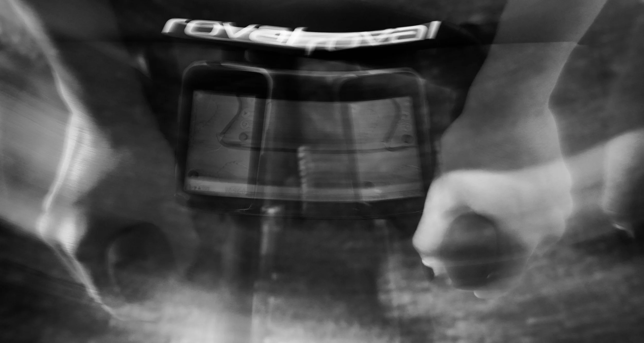 Black and white photograph of a Revlon lipstick inside a hand, with the hand creating a frame around the lipstick.