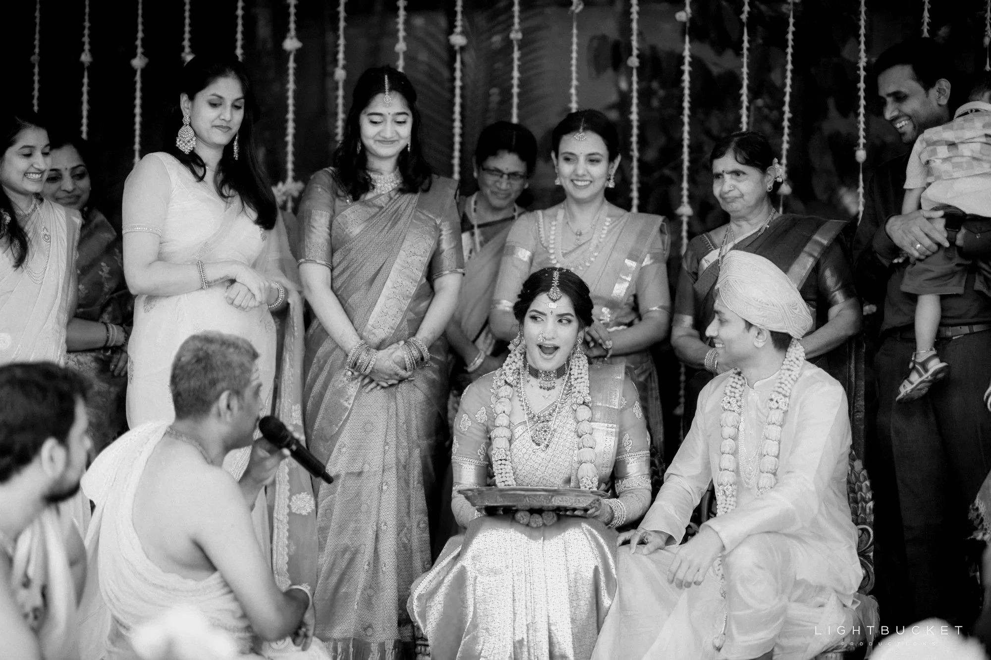 Indian wedding ceremony with bride, groom, and family members gathered together.