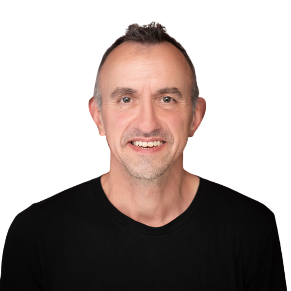 Smiling middle-aged man with short, dark hair wearing a black shirt, against a black background.