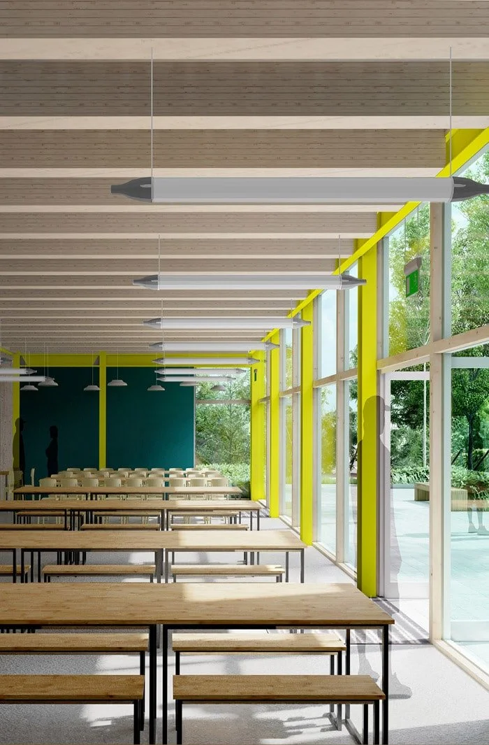 Empty cafeteria with long wooden tables and benches, large floor-to-ceiling windows, and modern lighting.