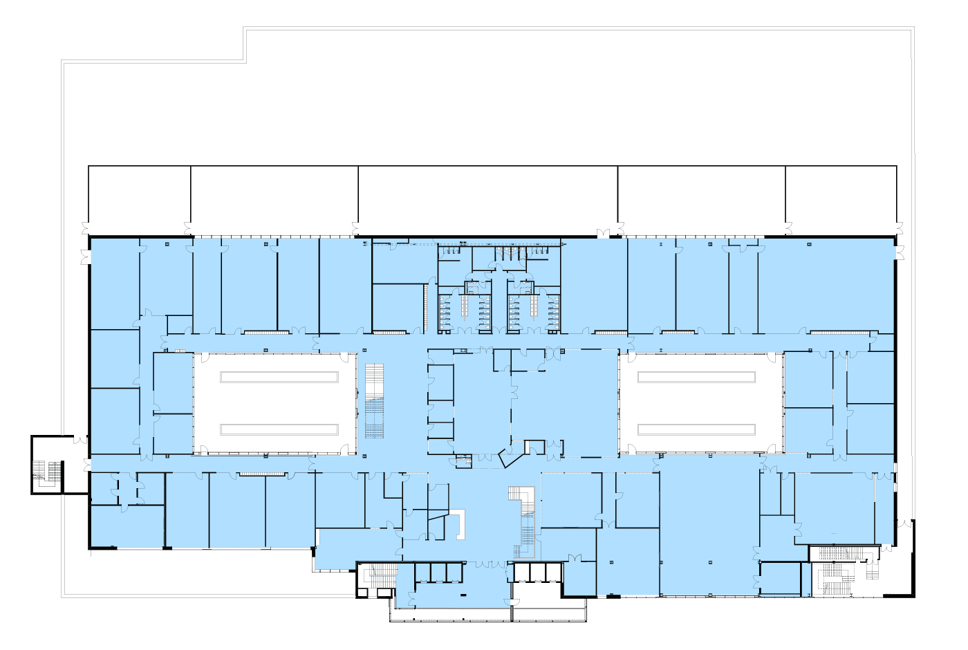 Floor plan of a large building with various rooms and hallways, shaded in light blue, including two large open areas in the center.