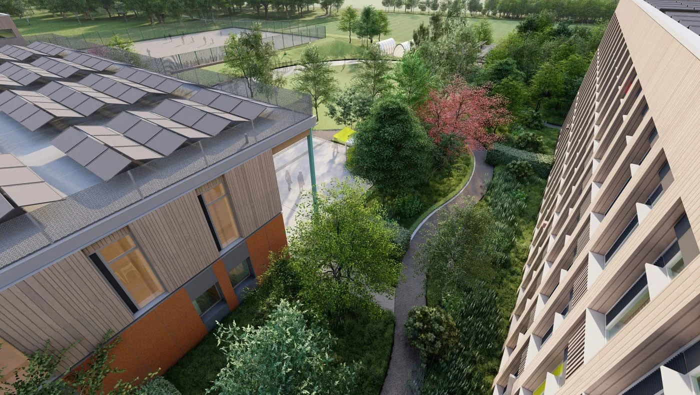 Aerial view of a green residential complex with pathways, trees, and a sports court between two modern buildings with solar panels on the roof.