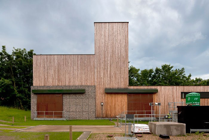 Side elevation view of the Water Treatment Facility building with wooden and concrete exterior, metal railings.