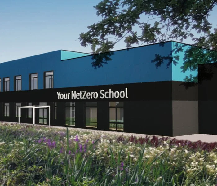 Rendering of a modern school building with blue and black exterior, labeled 'Your NetZero School', surrounded by a garden and trees.