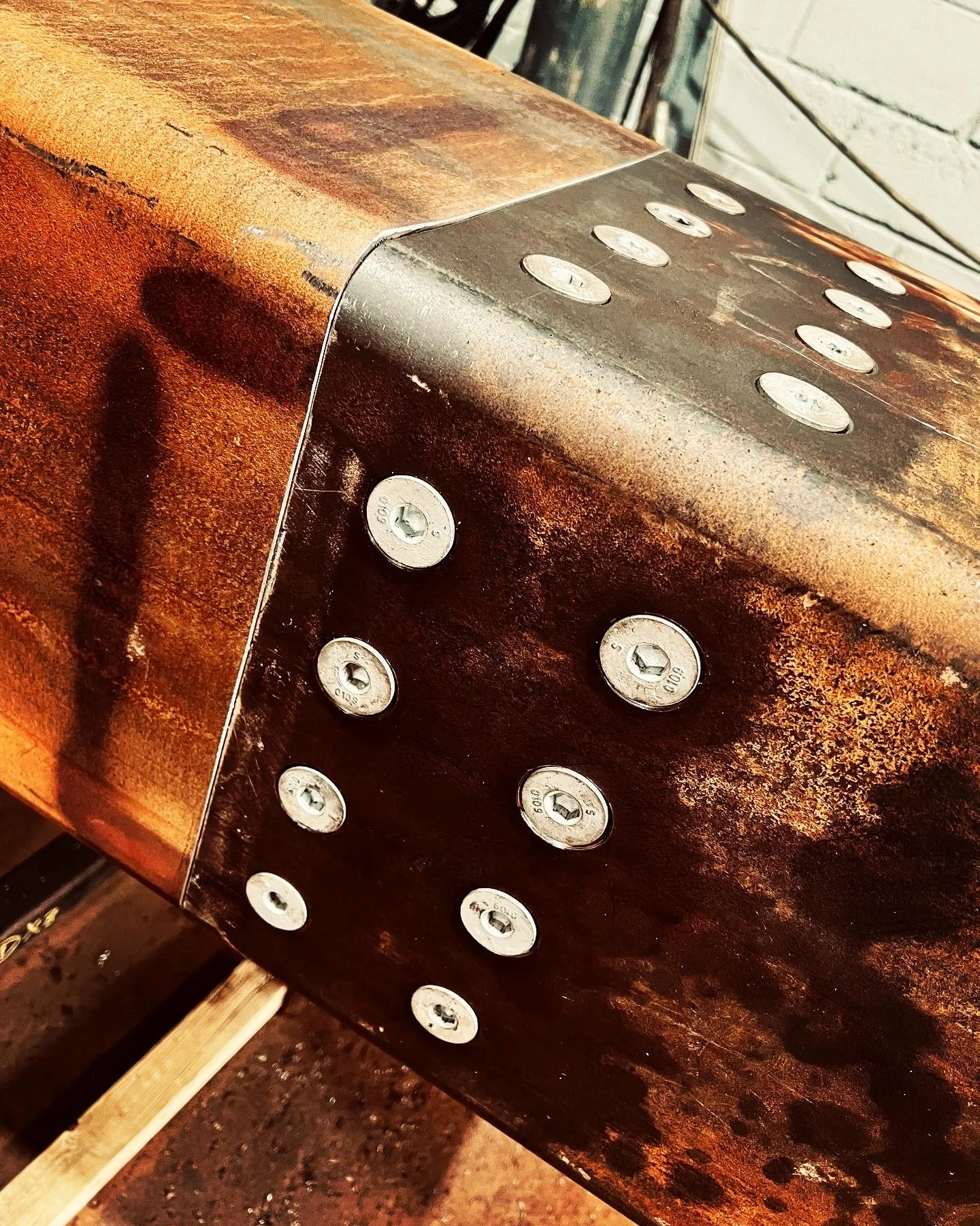 Close-up of a mild steel SHS with countersunk fixings.