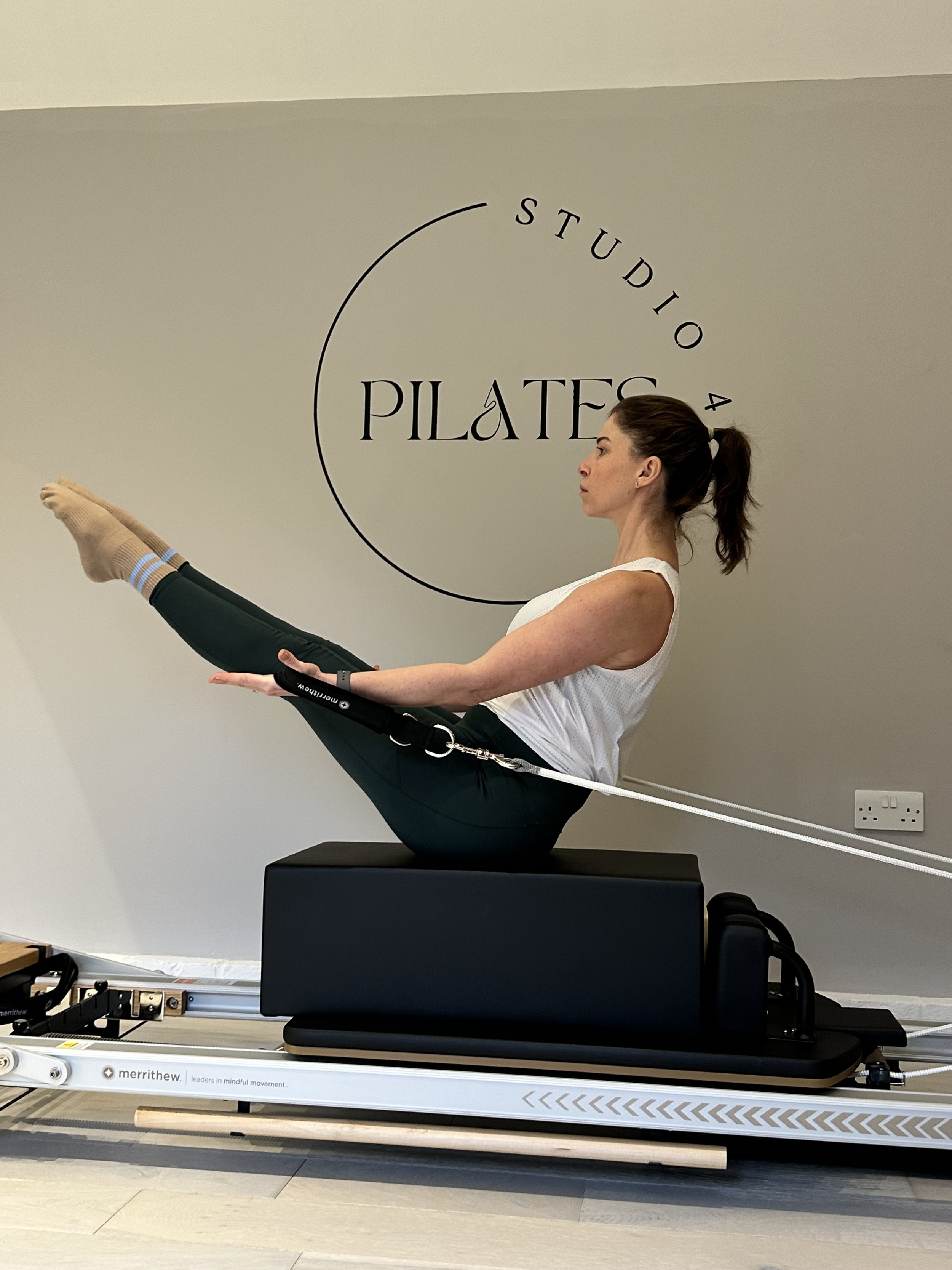 Instructor Chloe demonstrating on reformer pilates bed