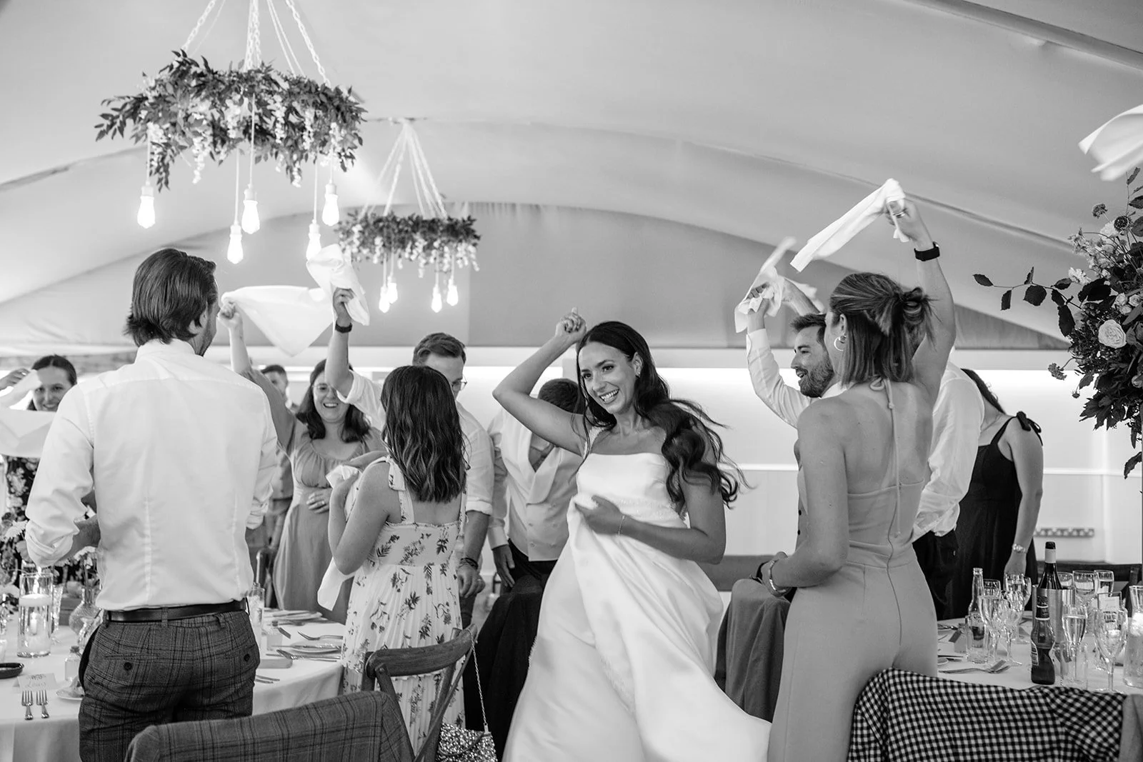 People celebrating and dancing at a wedding reception indoors.