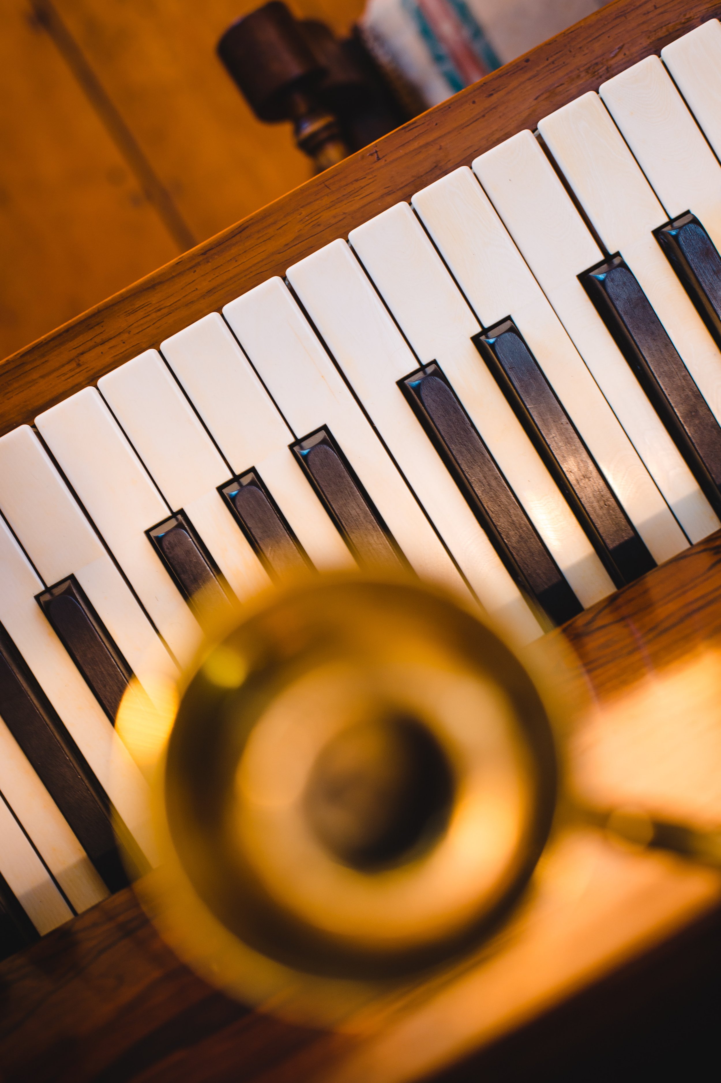 Piano keys with blurred brass instrument overlay