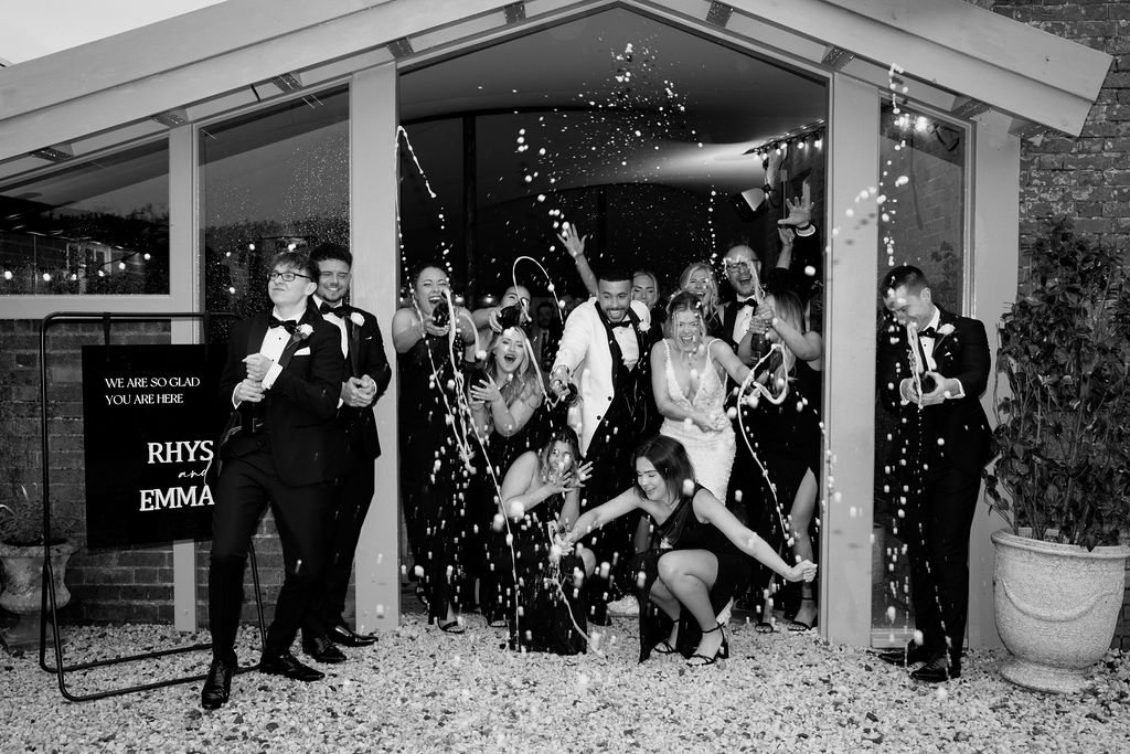 Group celebrating with champagne at a wedding, people in formal attire.