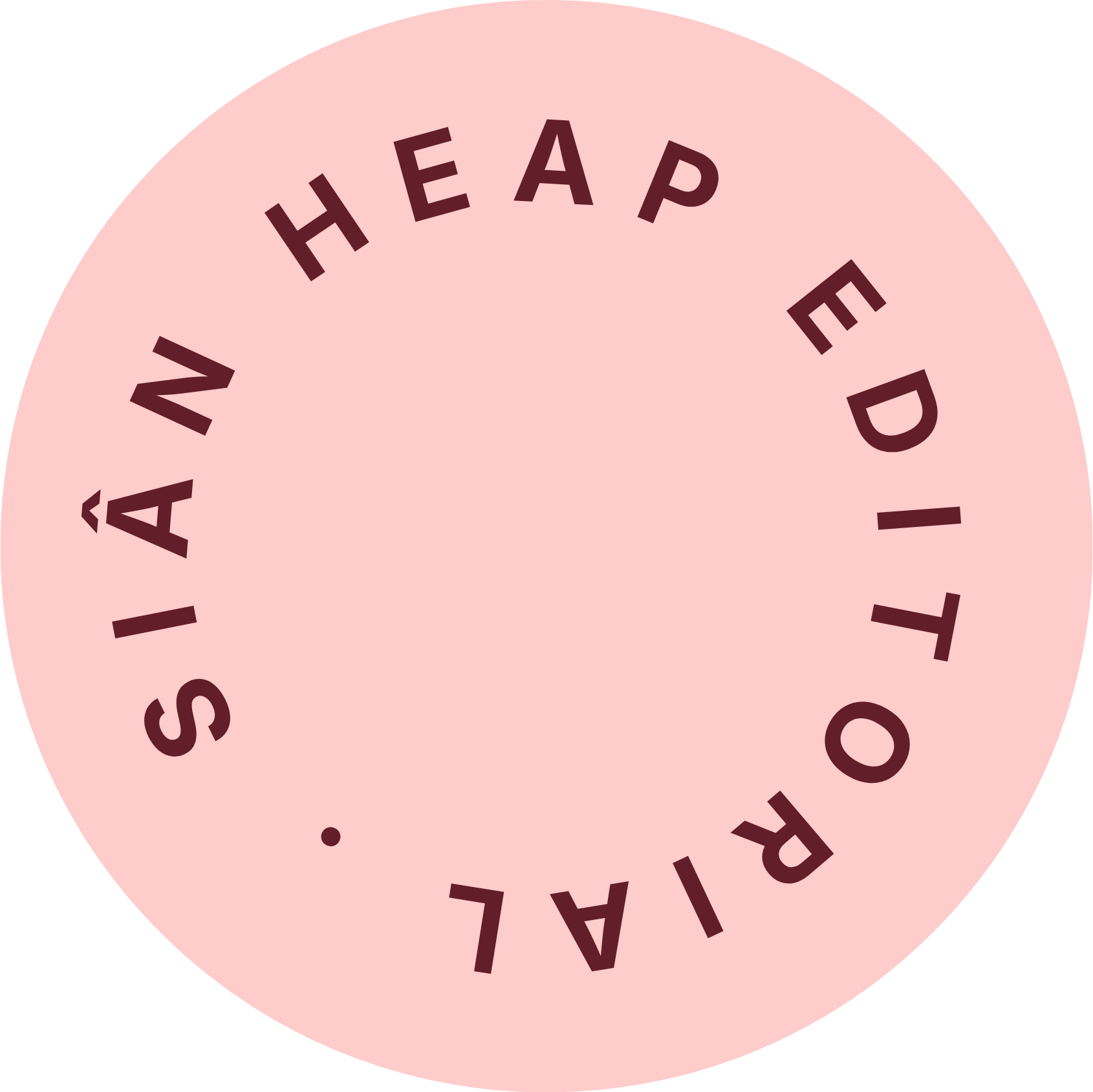 Close-up of a round pink label with the text 'RAILWAY STATION' written in dark maroon letters, arranged in a circular pattern around the edge.