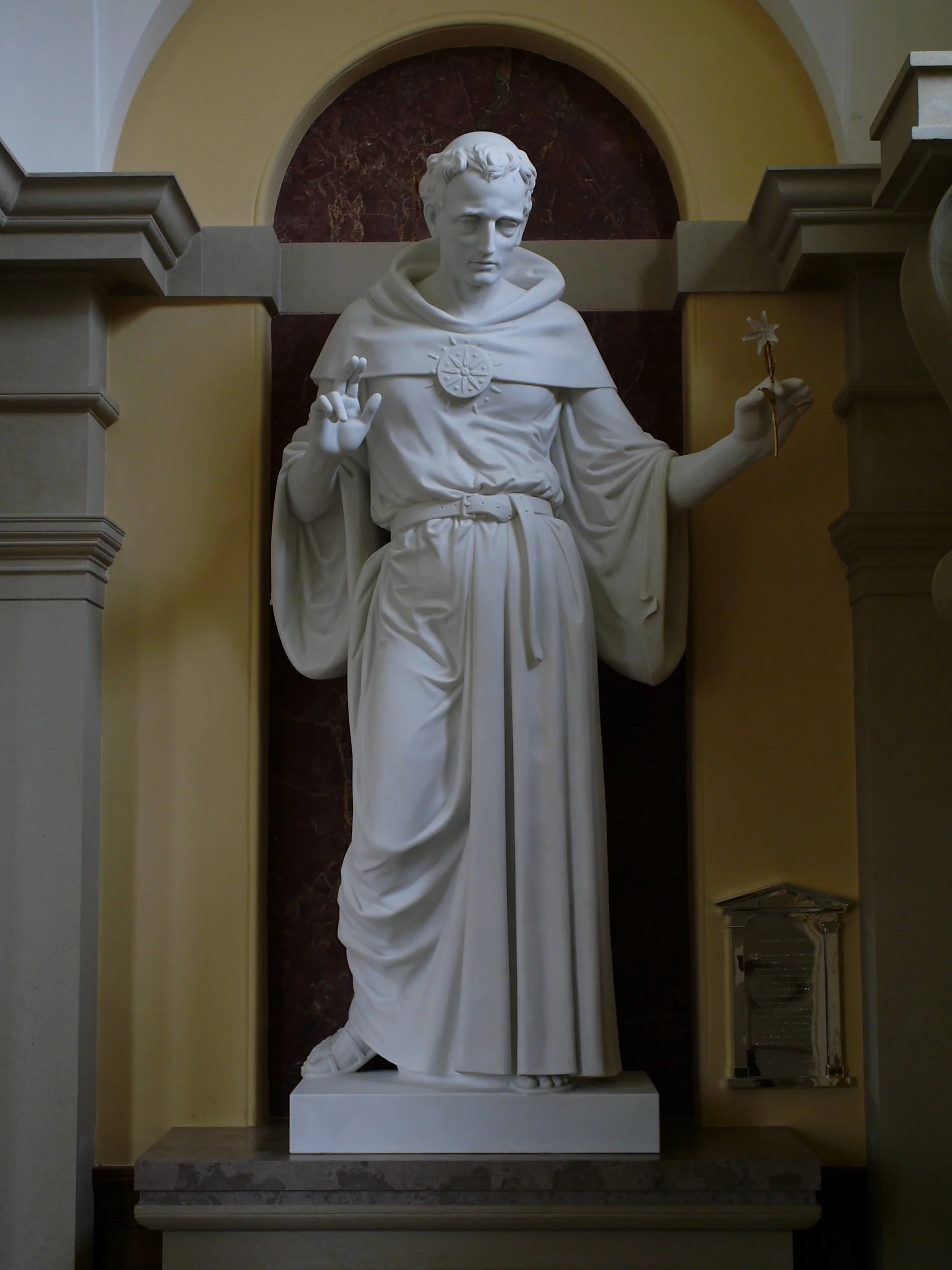 Marble statue of a saint displayed within an architectural niche inside the private Catholic chapel.