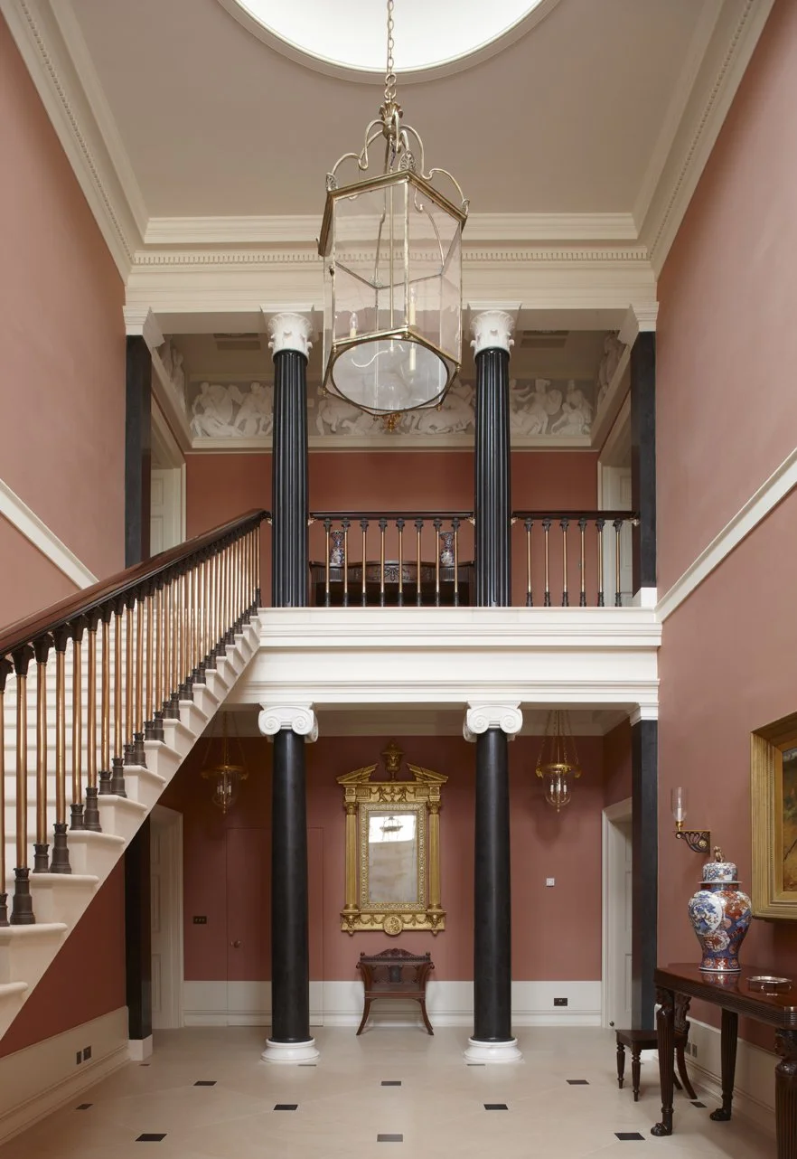 Grand classical stair hall with columns and decorative frieze in Gloucestershire country house by Craig Hamilton Architects