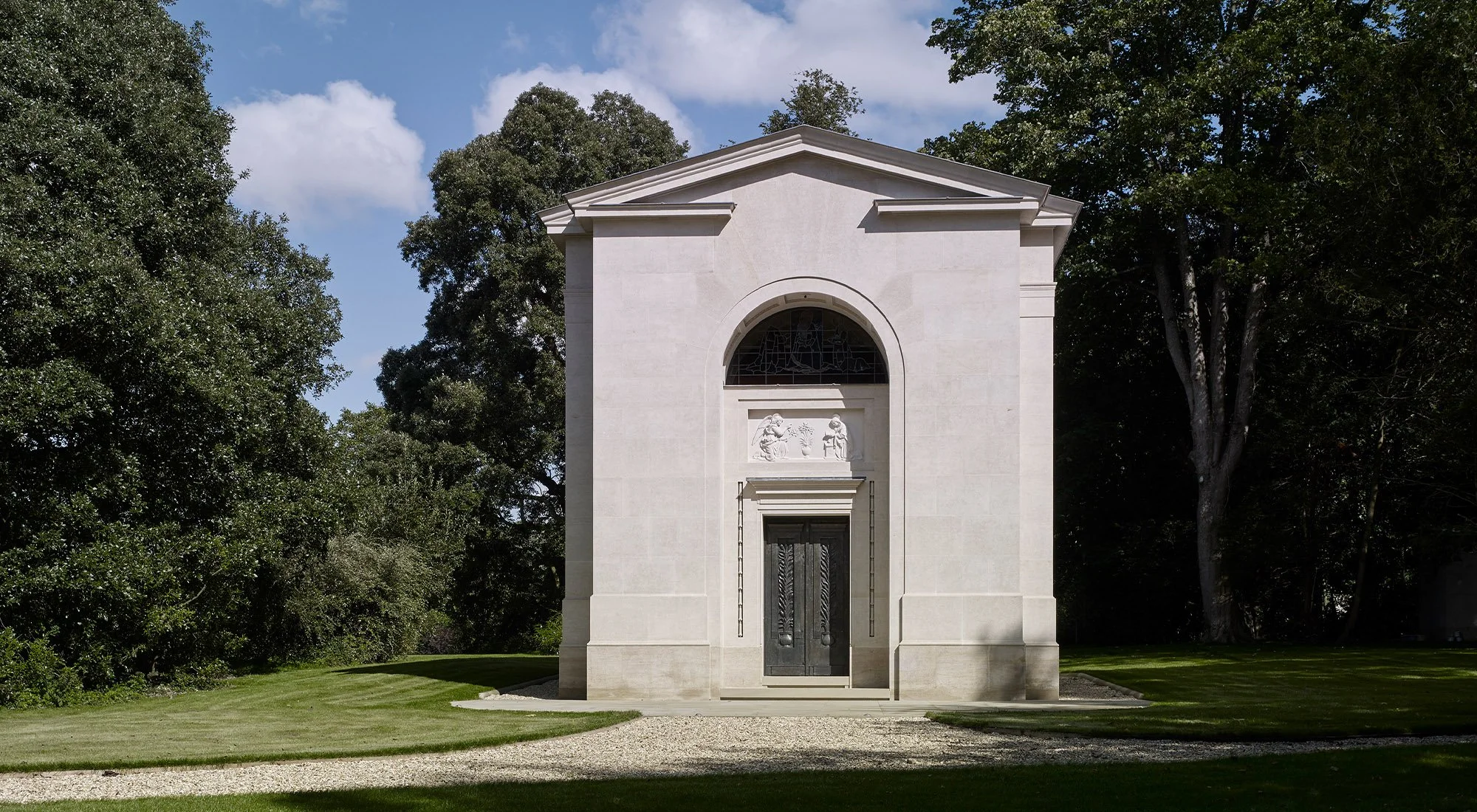 Classical stone chapel at Williamstrip estate designed by Craig Hamilton Architects, viewed from the front within a landscaped parkland setting.