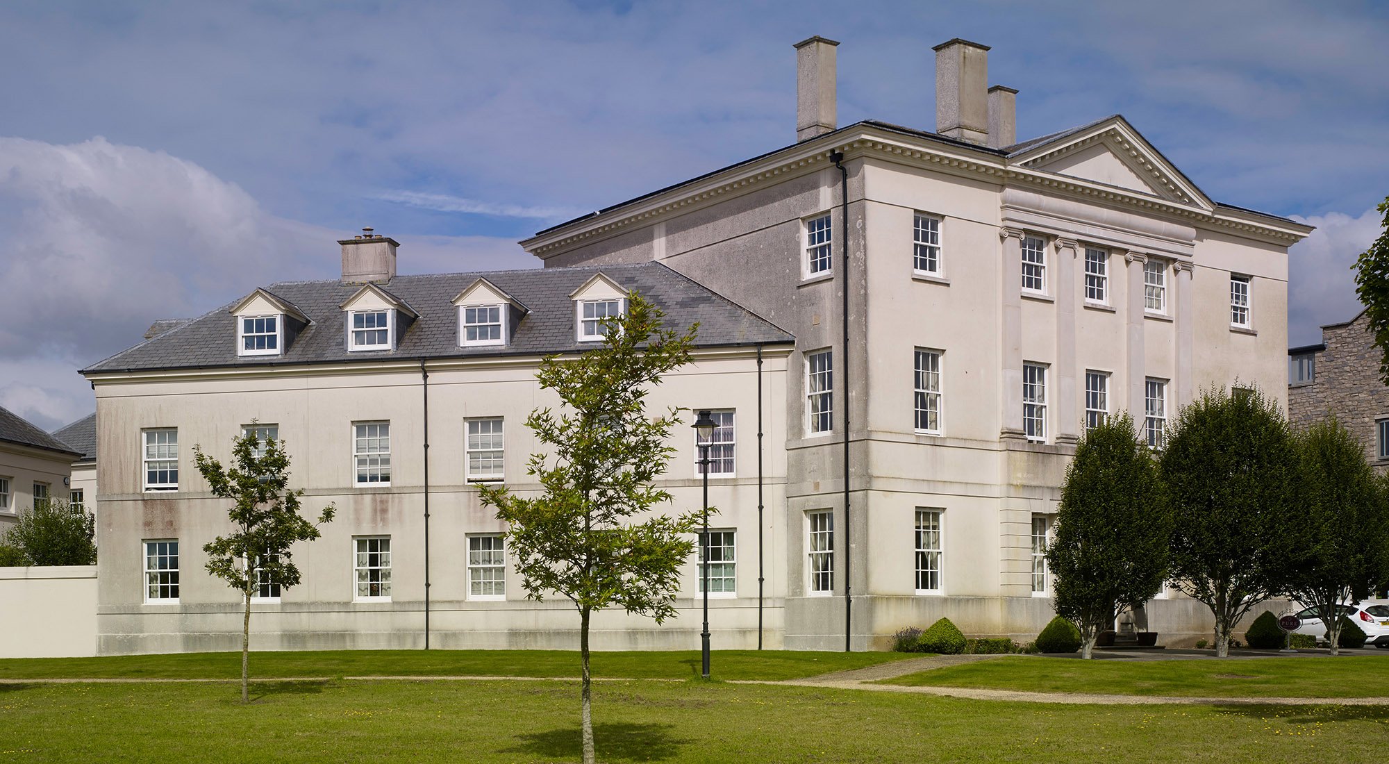 Side elevation of a classical townhouse overlooking landscaped gardens at Poundbury, Dorchester, Dorset.