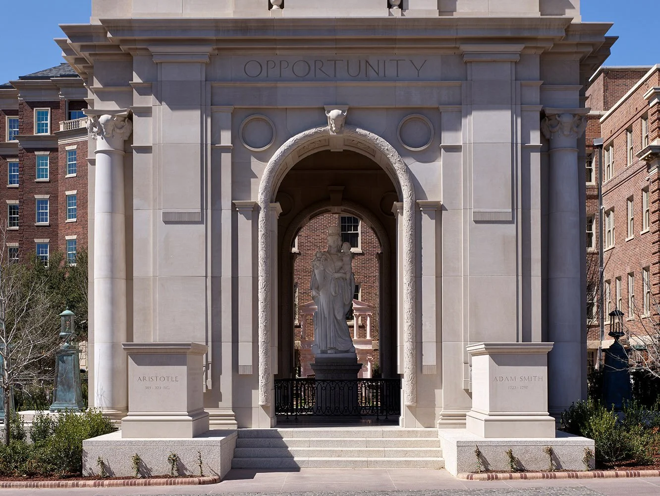 Monumental classical archway and stone colonnade at The Campanile in Dallas, Texas.
