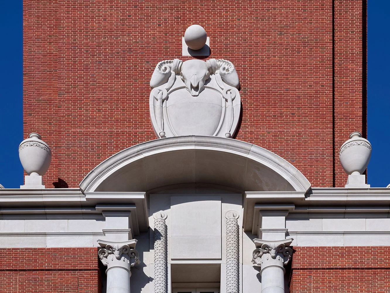 Carved stone pediment with ram’s head motif and classical detailing on The Campanile in Dallas.