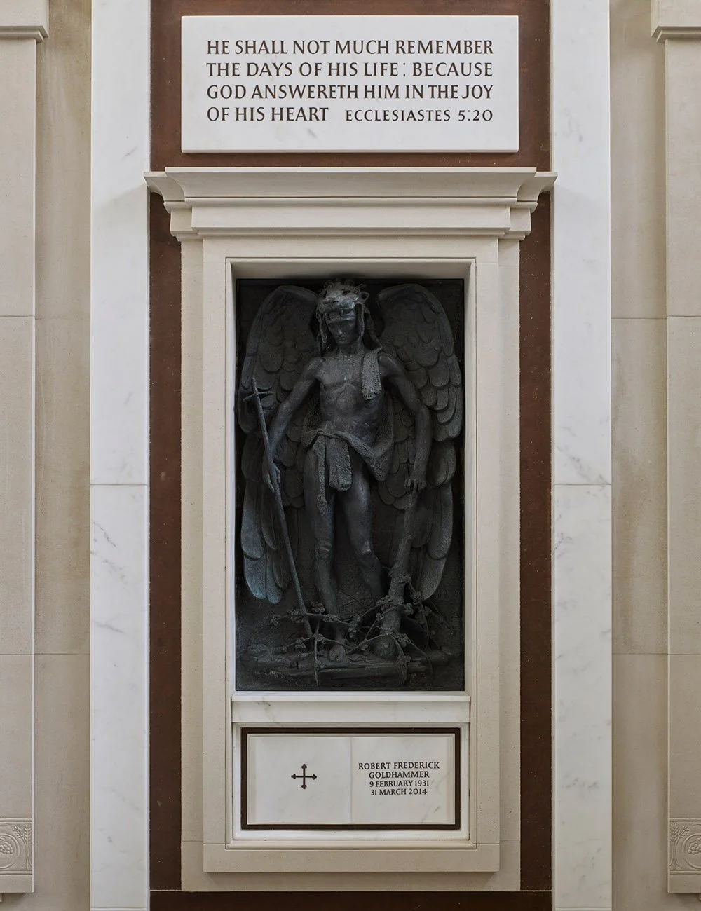 Bronze angel memorial sculpture set within a carved stone niche inside the mausoleum.
