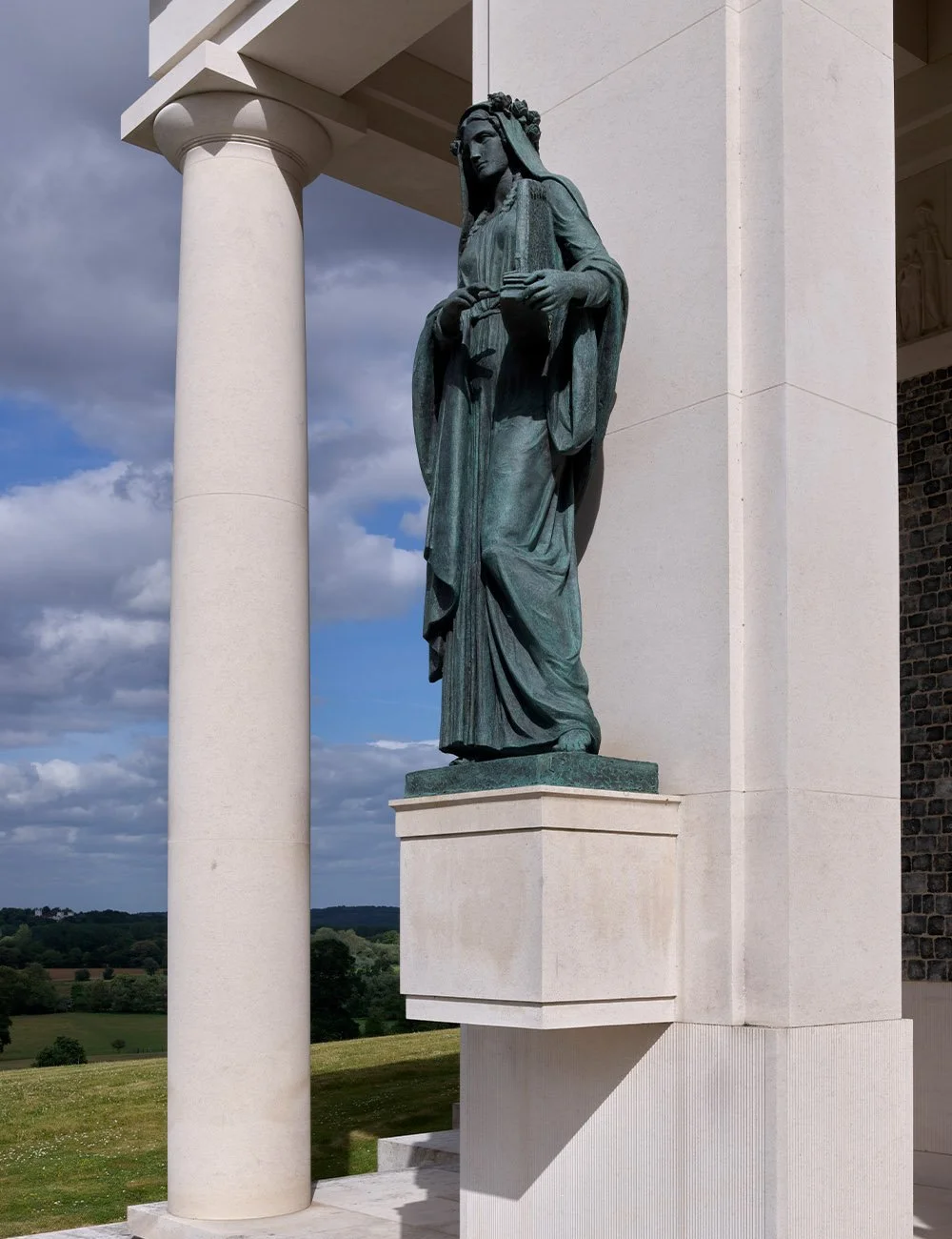 Bronze religious statue set within the classical stone portico of The Chapel of Christ the Redeemer at Culham.