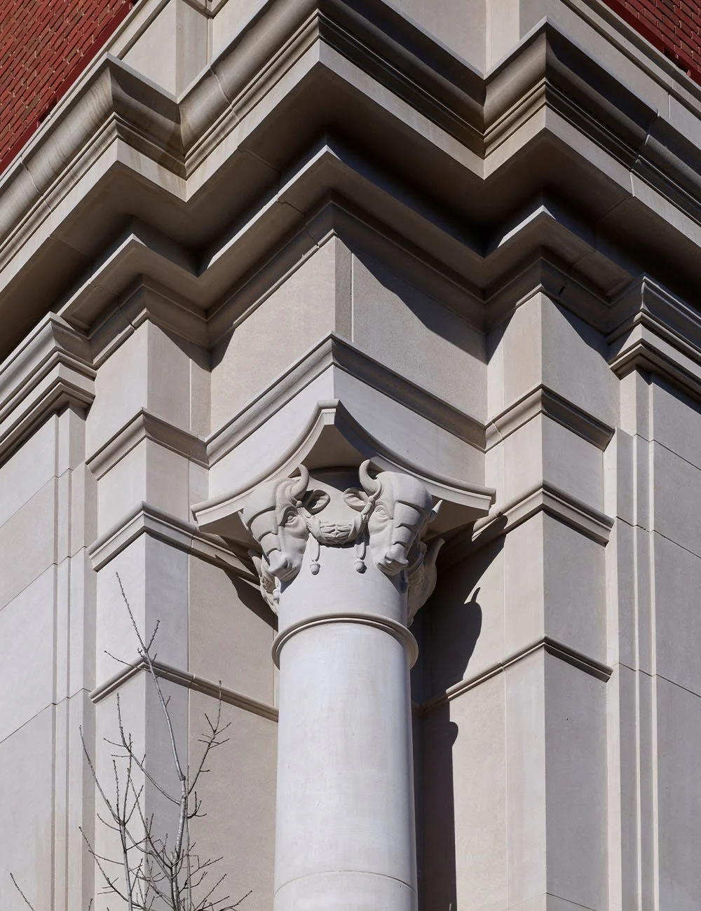 Close-up of a carved Corinthian capital and classical stone detailing on The Campanile in Dallas, Texas.